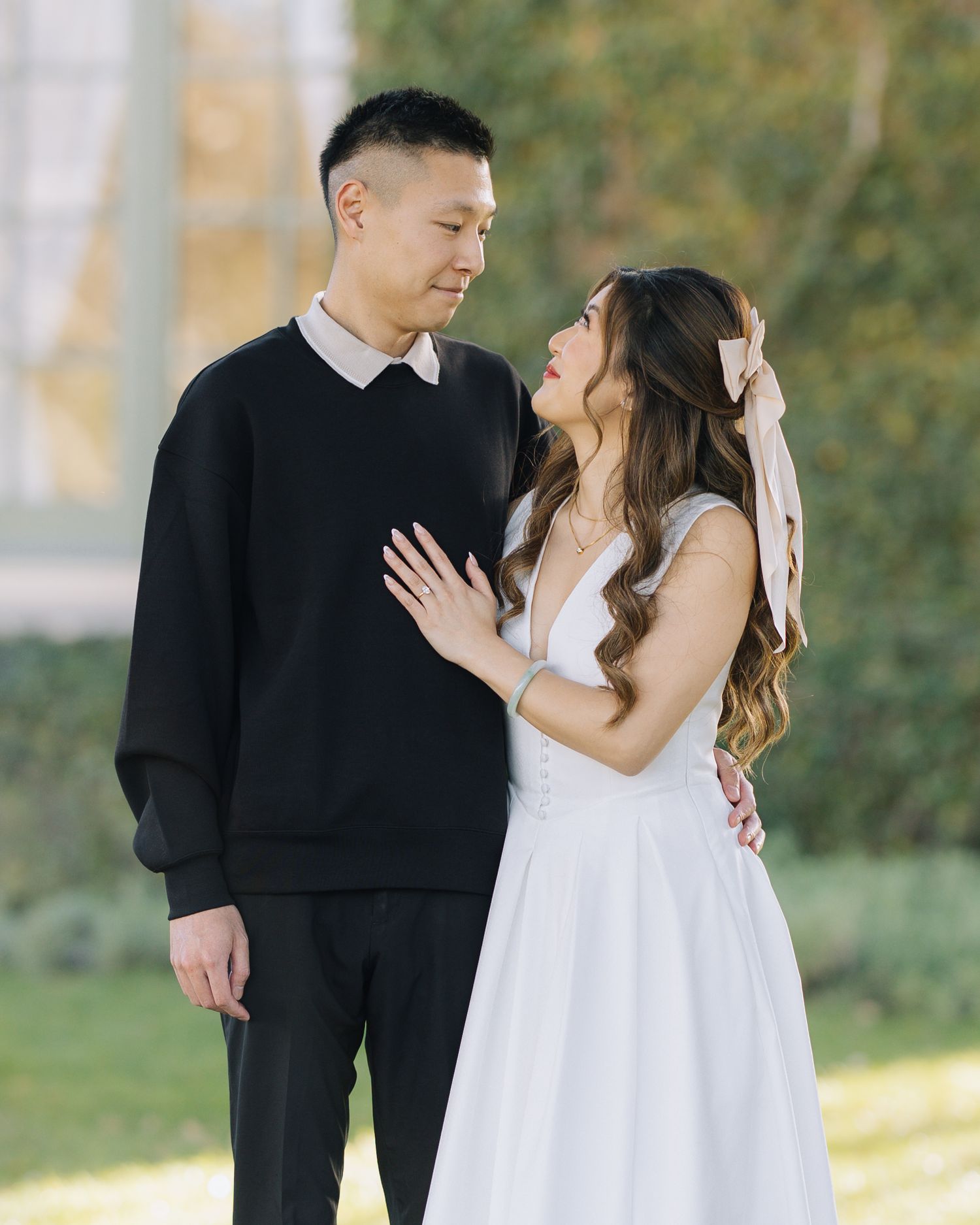 Couple sharing a tender moment in a sunlit garden during an engagement photo session at Filoli Woodside CA.