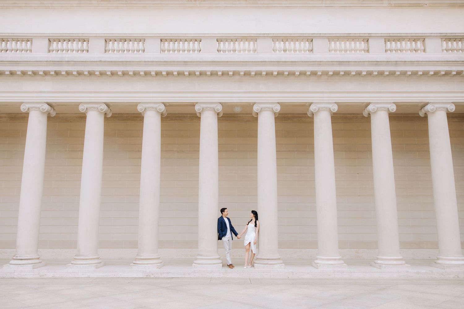Couple holding hands and facing each other during engagement photoshoot at Legion of Honor museum in SF.