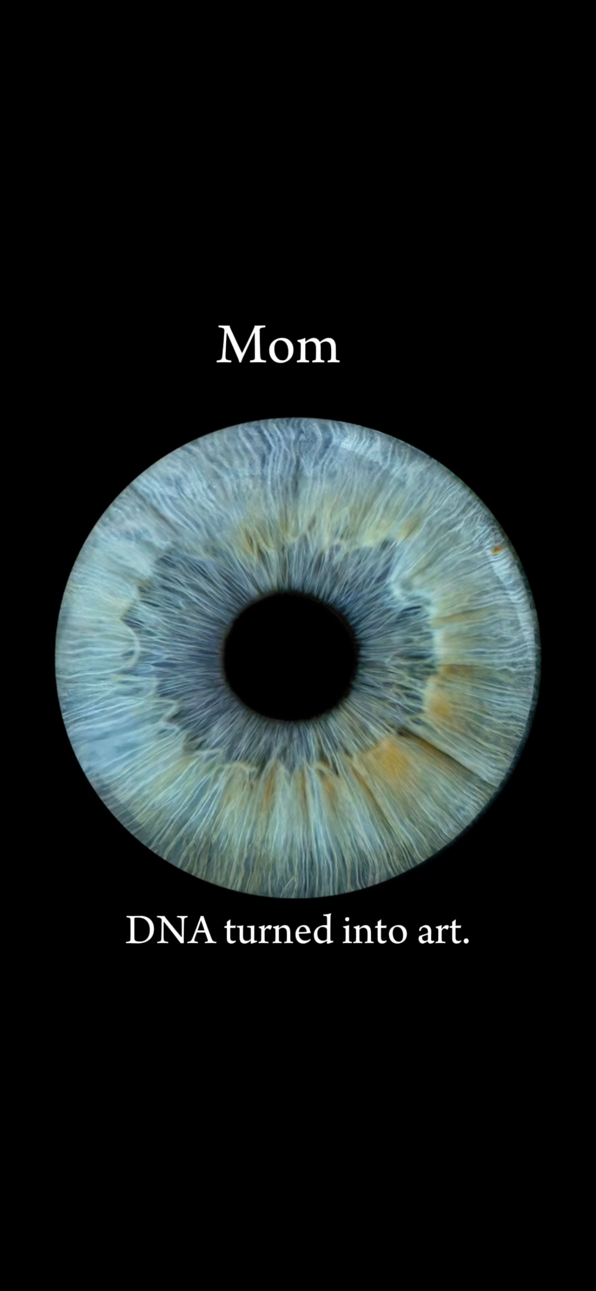Close-up macro photograph of a human iris labeled Mom on black background with DNA turned into art text.