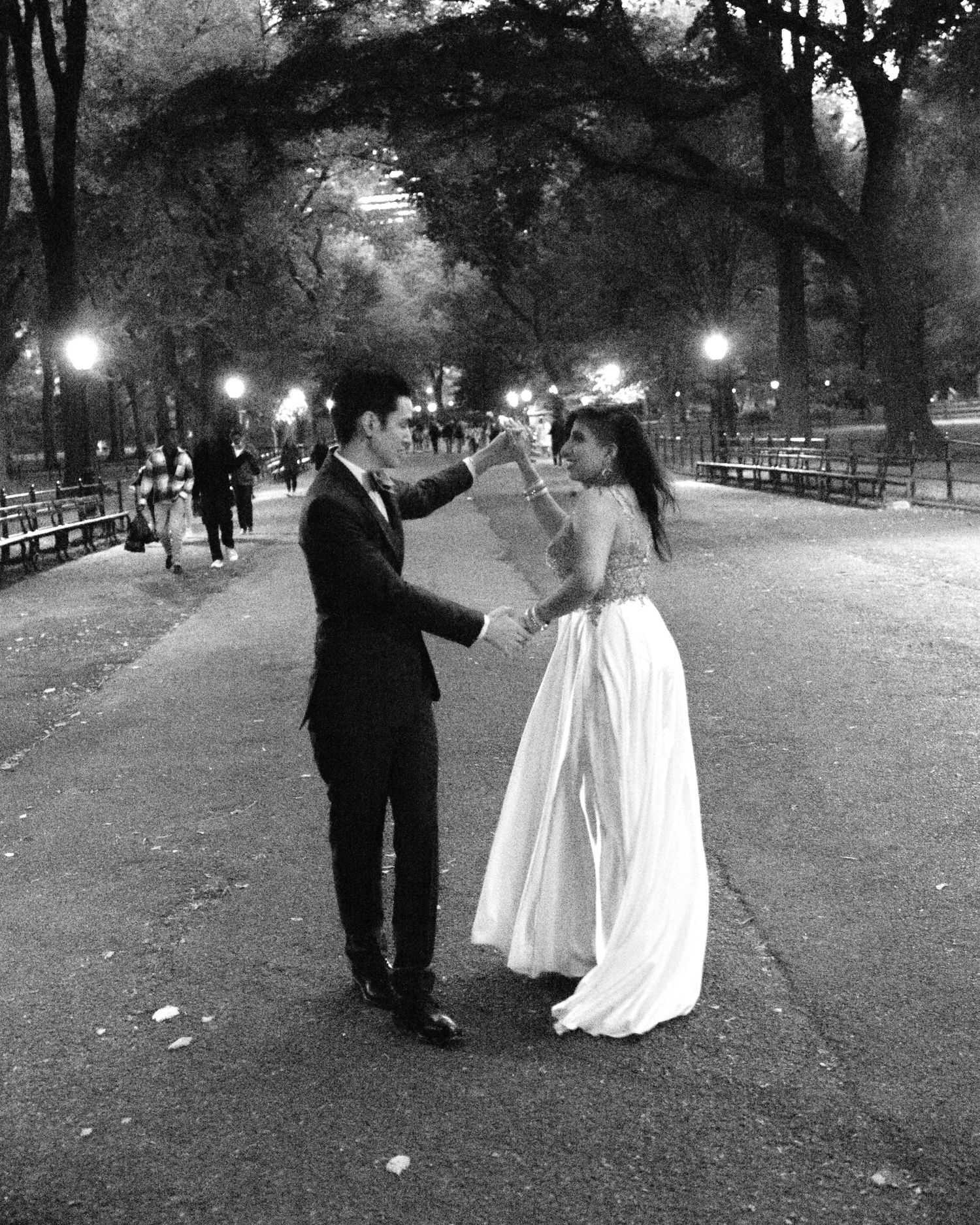 Black and White photo of married couple in suit and dress dancing in Central park. .