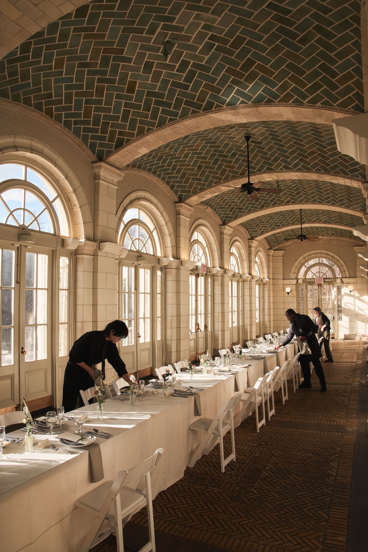 Wedding Event hall photography. Golden hour photo of wedding event staff setting the table.