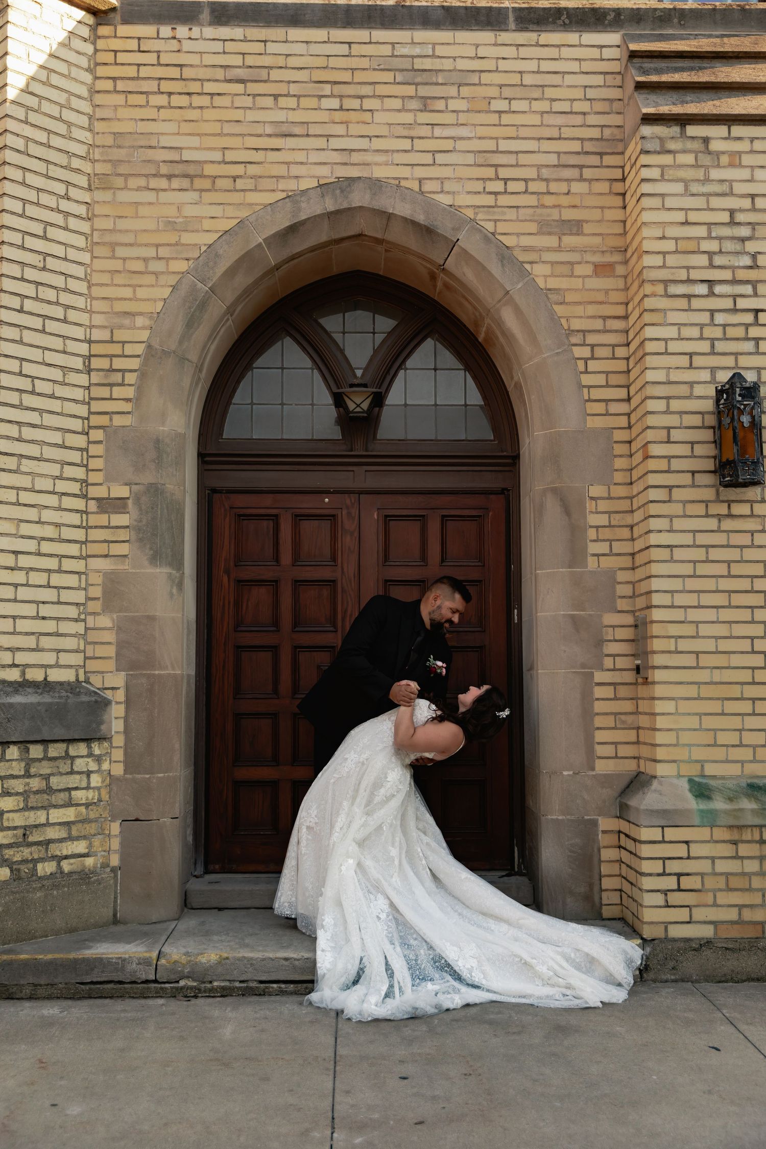 A series of four wedding photos showing a couple posing dramatically in front of an arched brick doorway.
