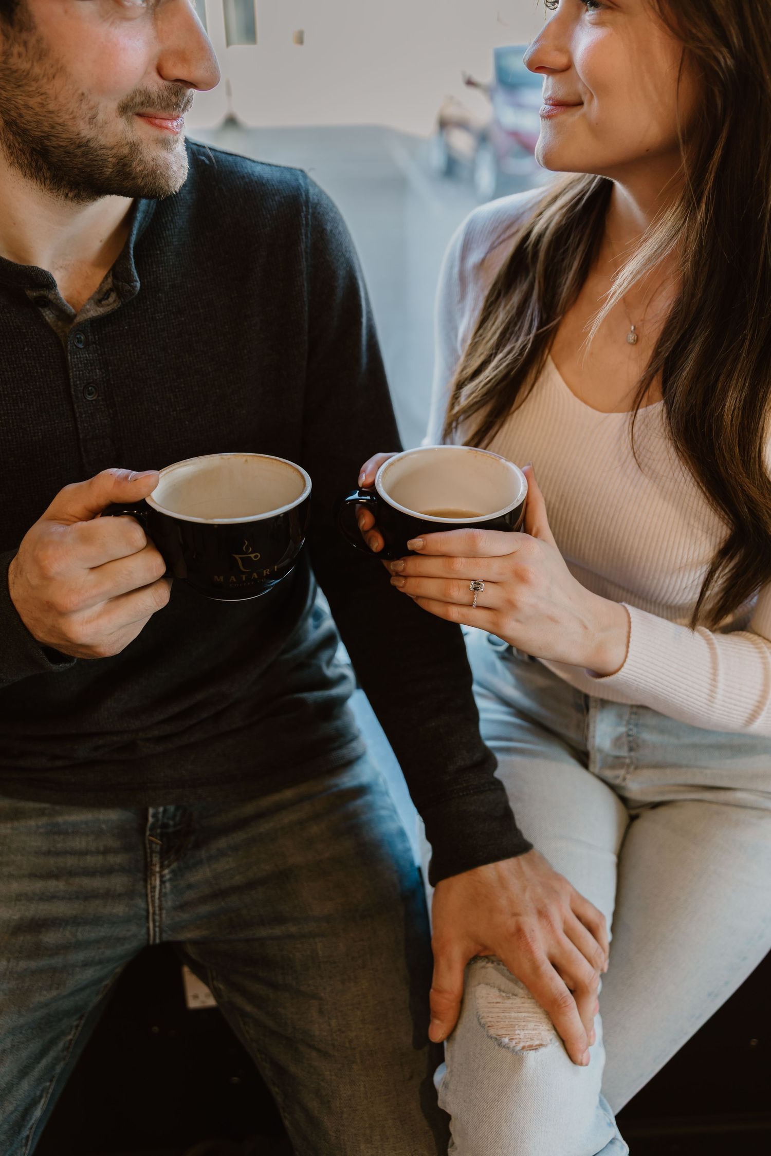 Couple enjoying coffee together while sitting casually and sharing an intimate moment at home.