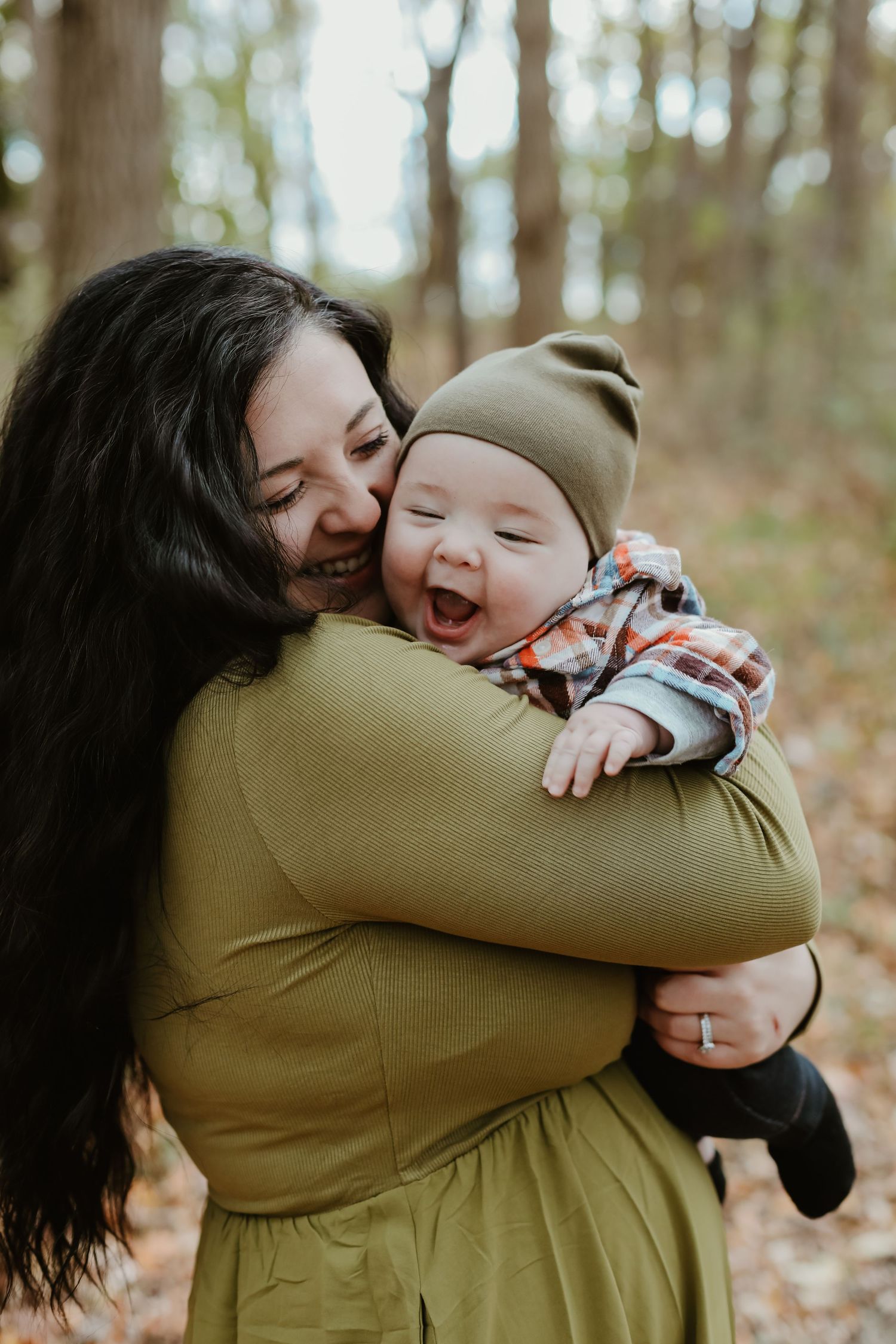 A tender embrace between a parent and child with joyful laughter among autumn leaves.