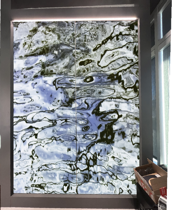 A photo of a blue, white and gray mural created from a photograph of water ripples.