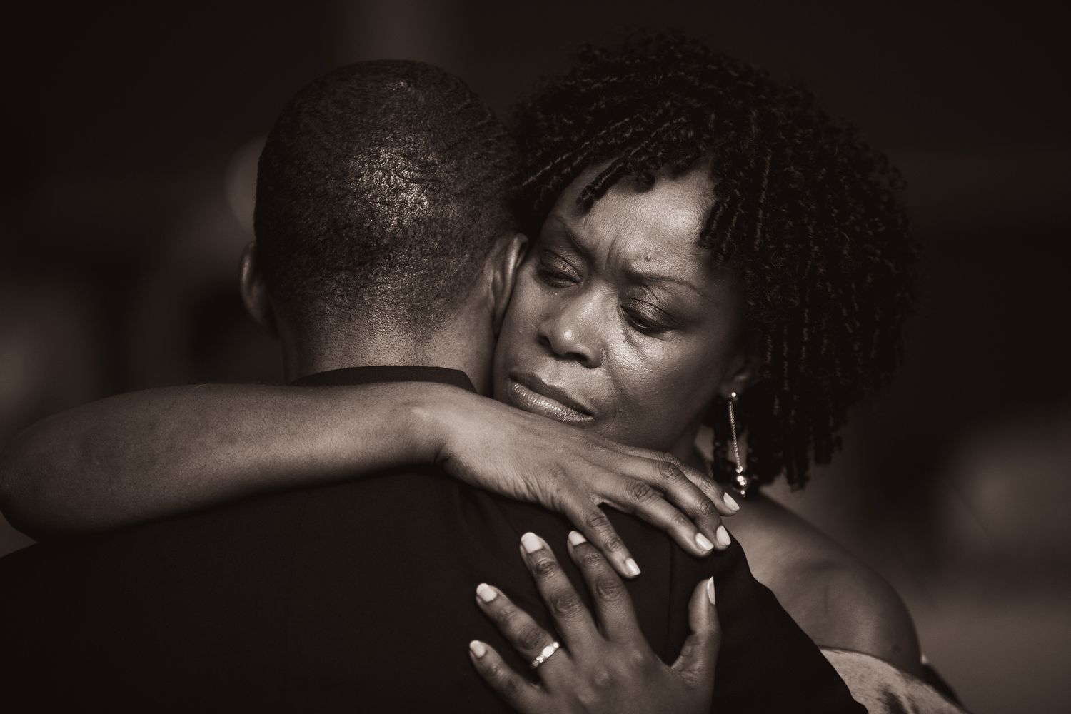 A tender embrace between two people captured in an intimate black and white photograph.