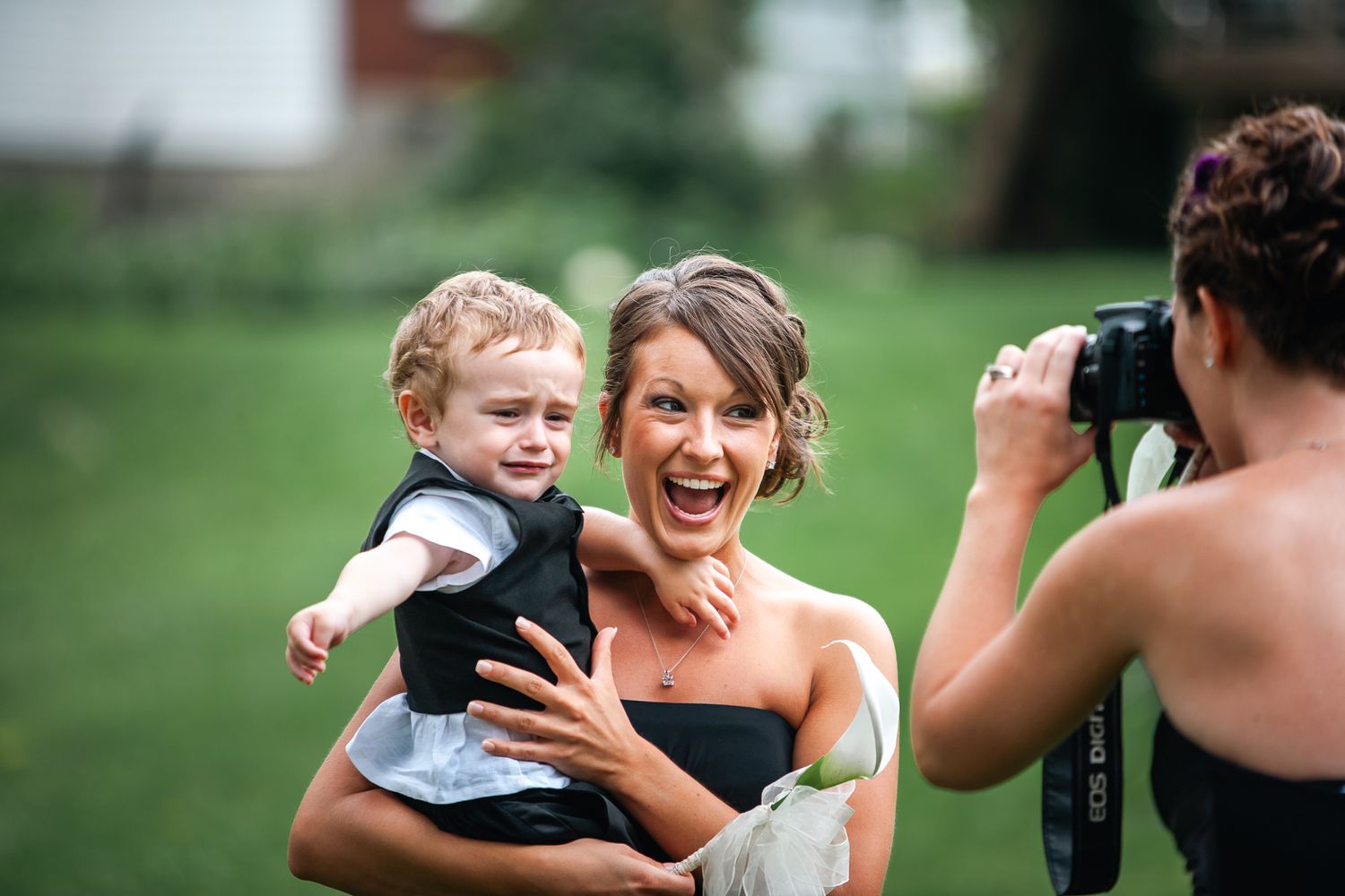 A photographer captures a candid moment of joy and laughter during an outdoor photoshoot.