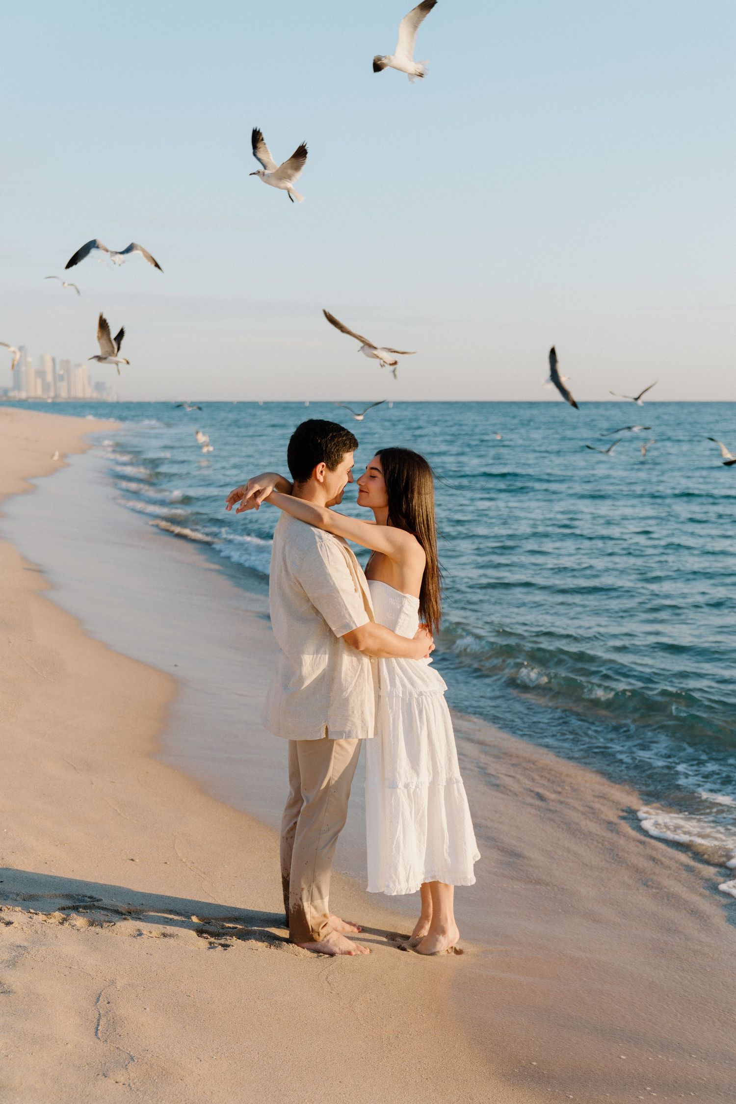 Romantic Miami beach photoshoot – couple embracing surrounded by seagulls