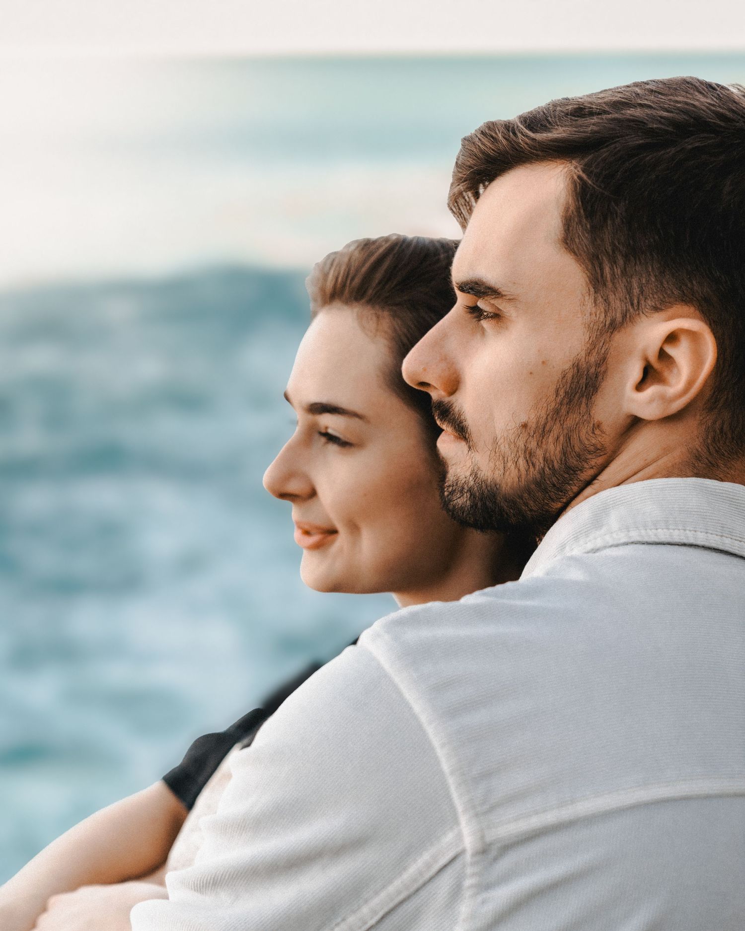 Cinematic portrait of a couple looking towards the ocean during an editorial-style photoshoot