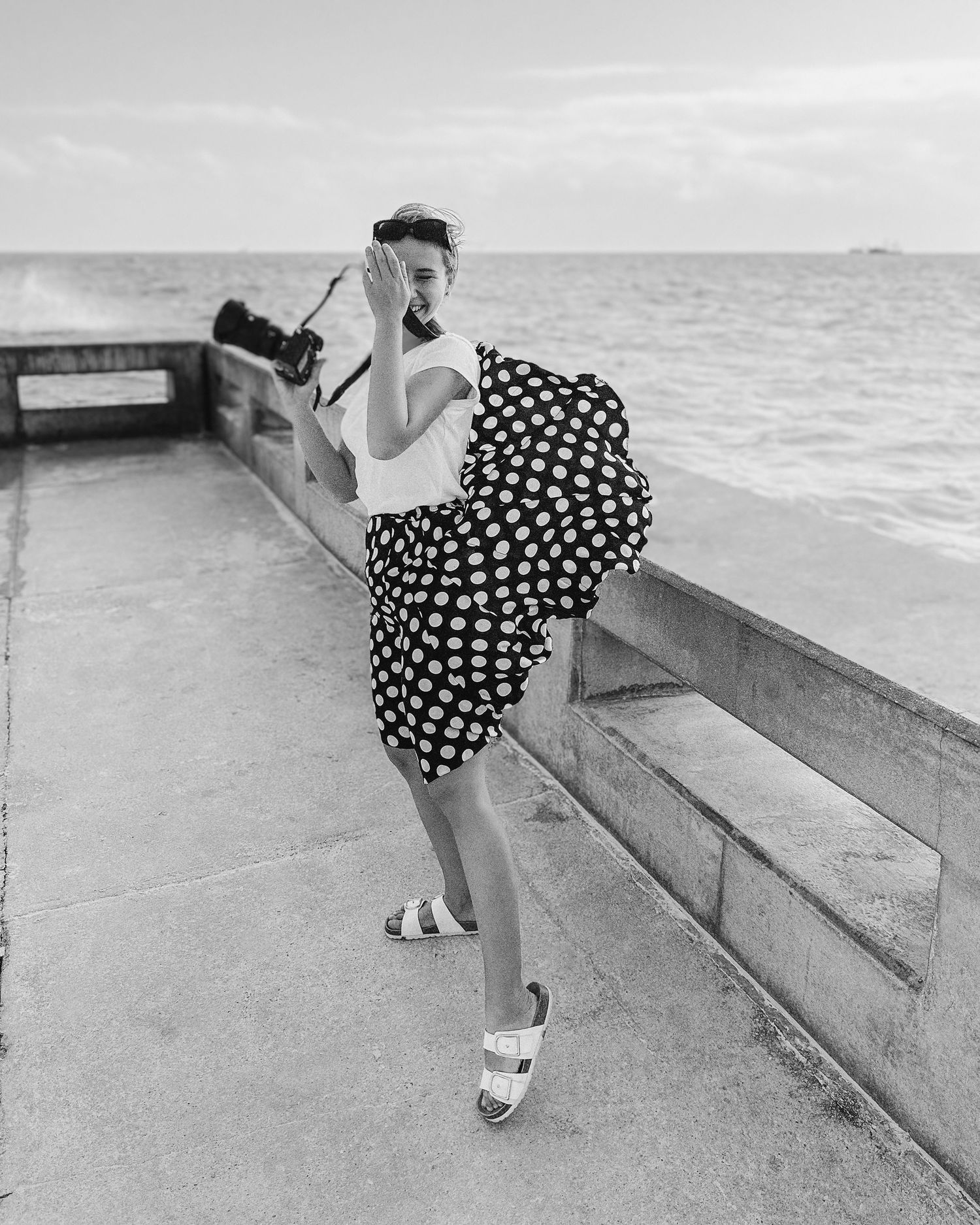 Miami black and white beach portrait – wind lifting woman's skirt in an emotional moment