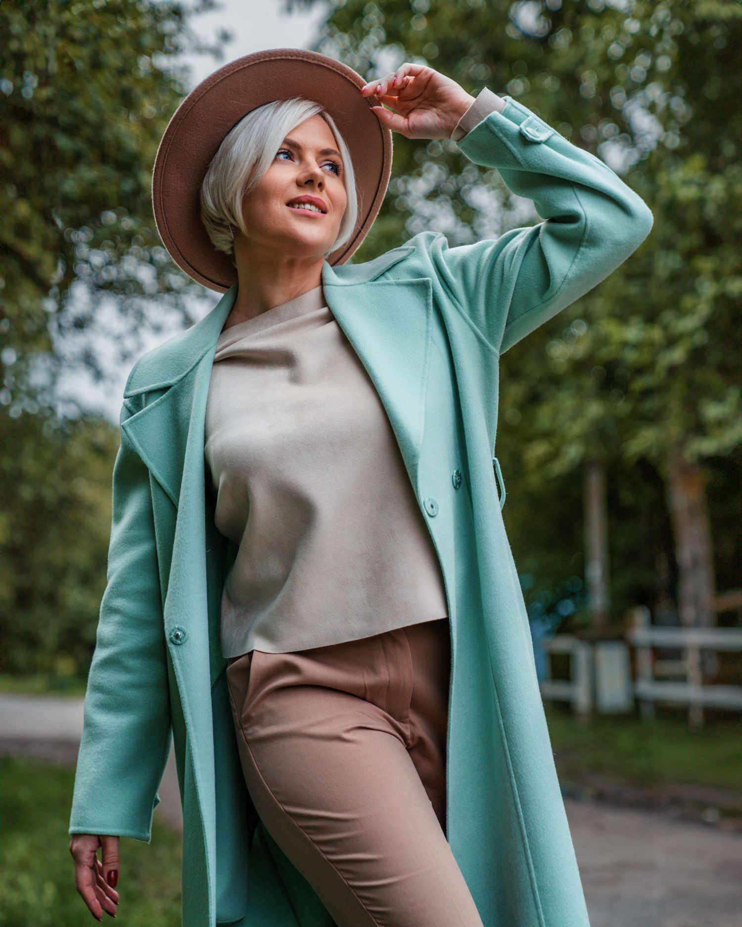Editorial-style fashion portrait of a woman captured from a low angle, highlighting her pose and style during a photoshoot