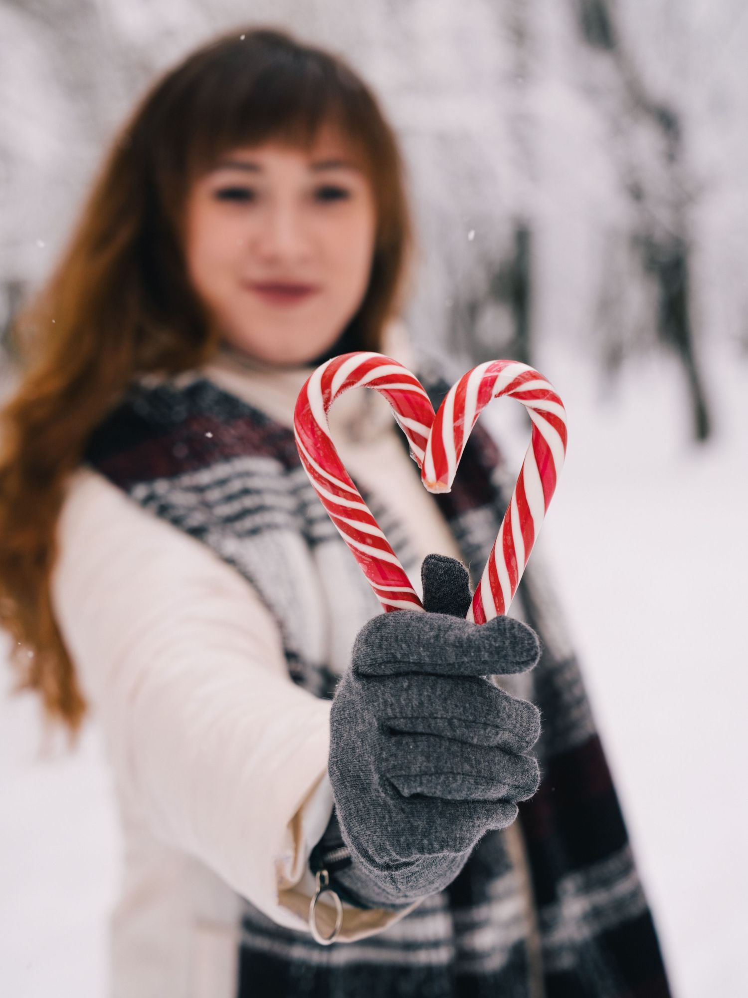 Candid portrait of a woman holding a heart-shaped lollipop and showing it during a photoshoot