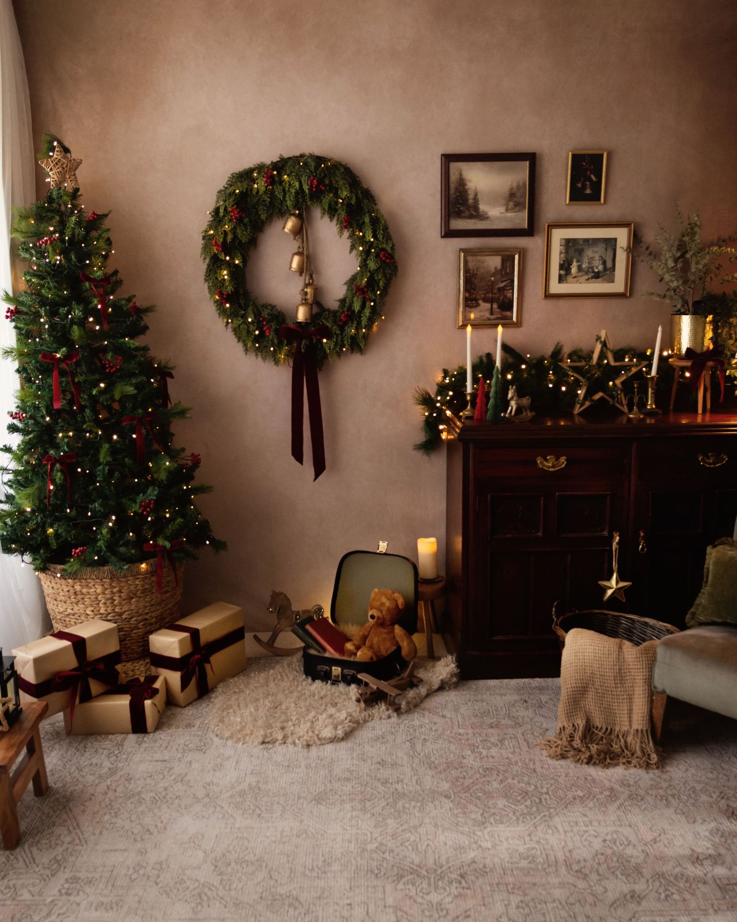 Cozy Christmas living room with decorated tree, wrapped gifts, wreath, candles, and vintage cabinet with holiday decor.