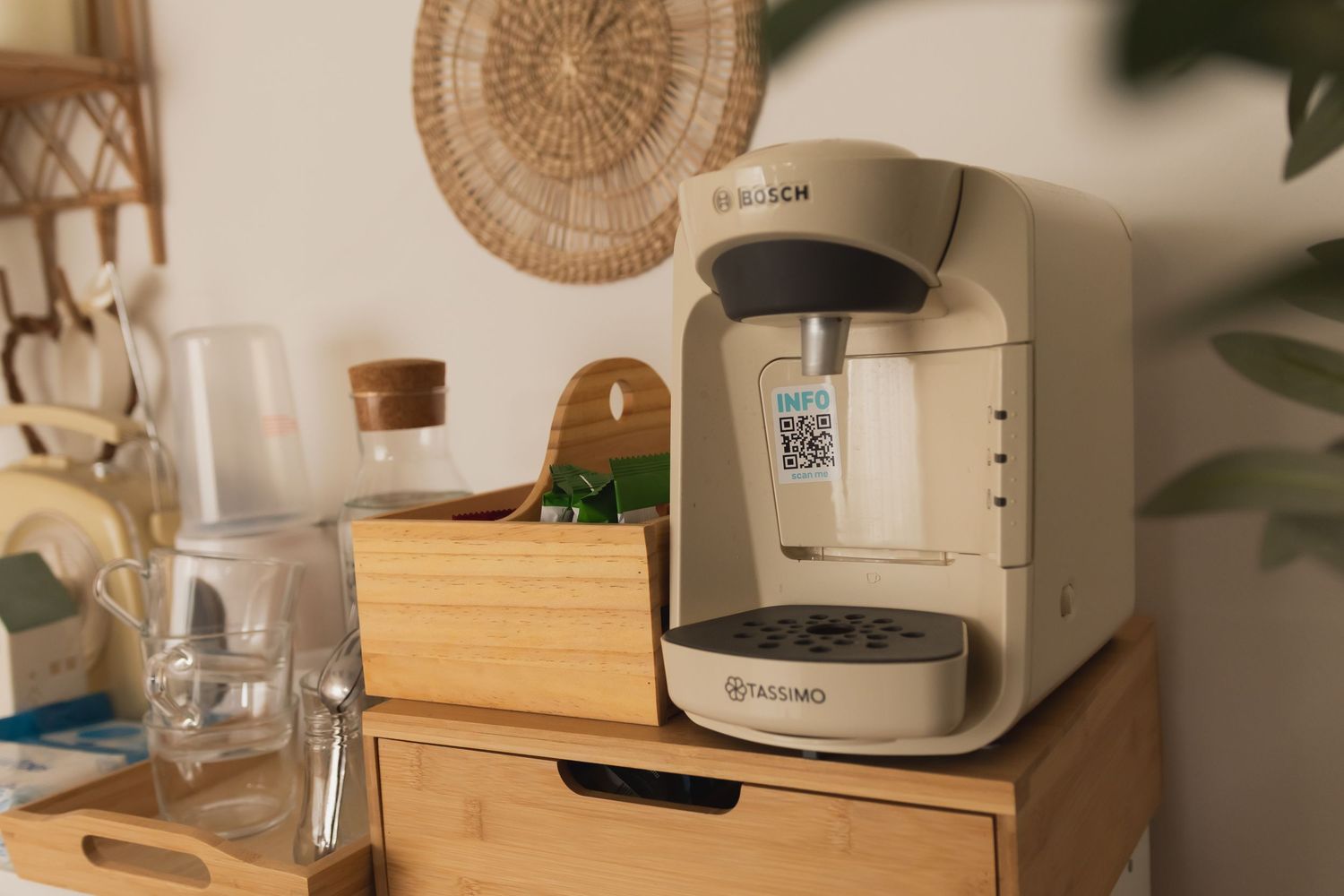 Bosch Tassimo coffee machine on a wooden drawer unit in a cozy boho kitchen setting.