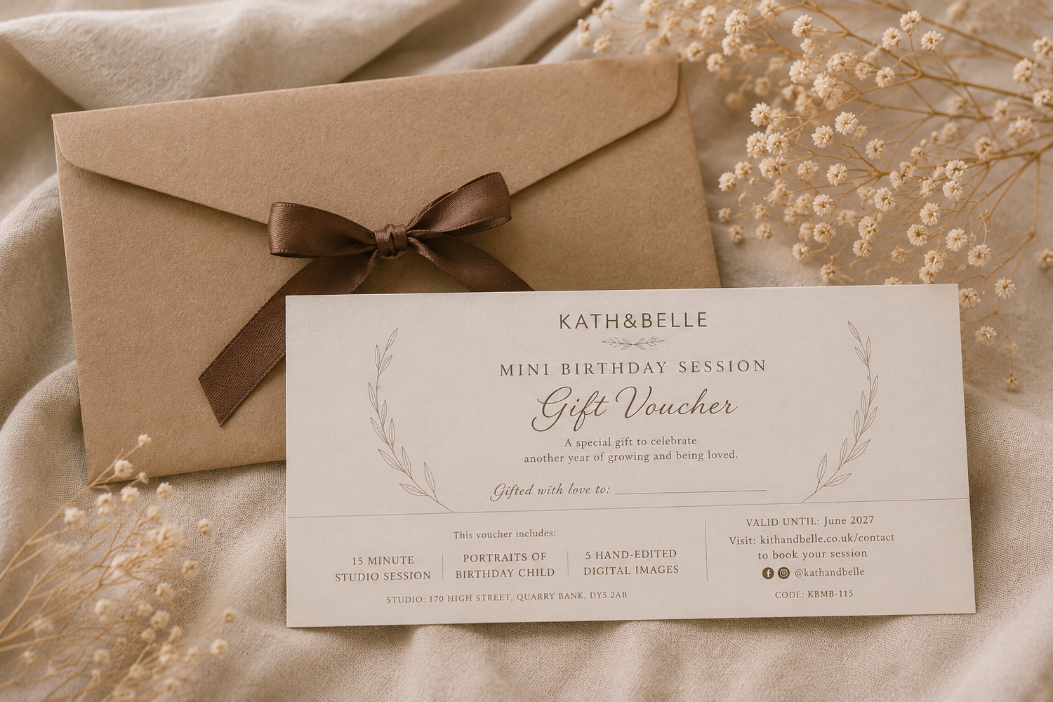 Kath & Belle mini birthday session gift voucher with kraft envelope and brown ribbon bow on beige fabric.