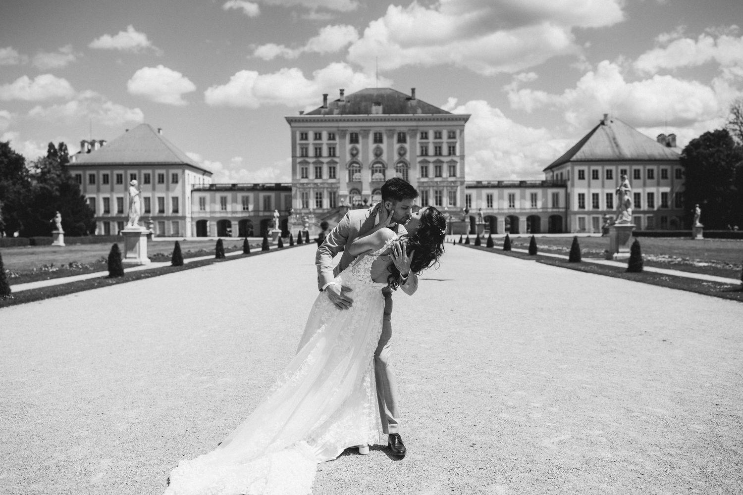 Black and white wedding photos show a couple celebrating at a grand palace venue with elegant architectural details.