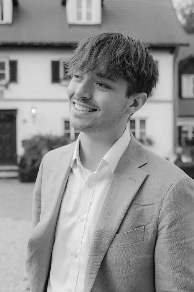 A series of black and white portraits showing someone in a light colored blazer and white shirt smiling at the camera.