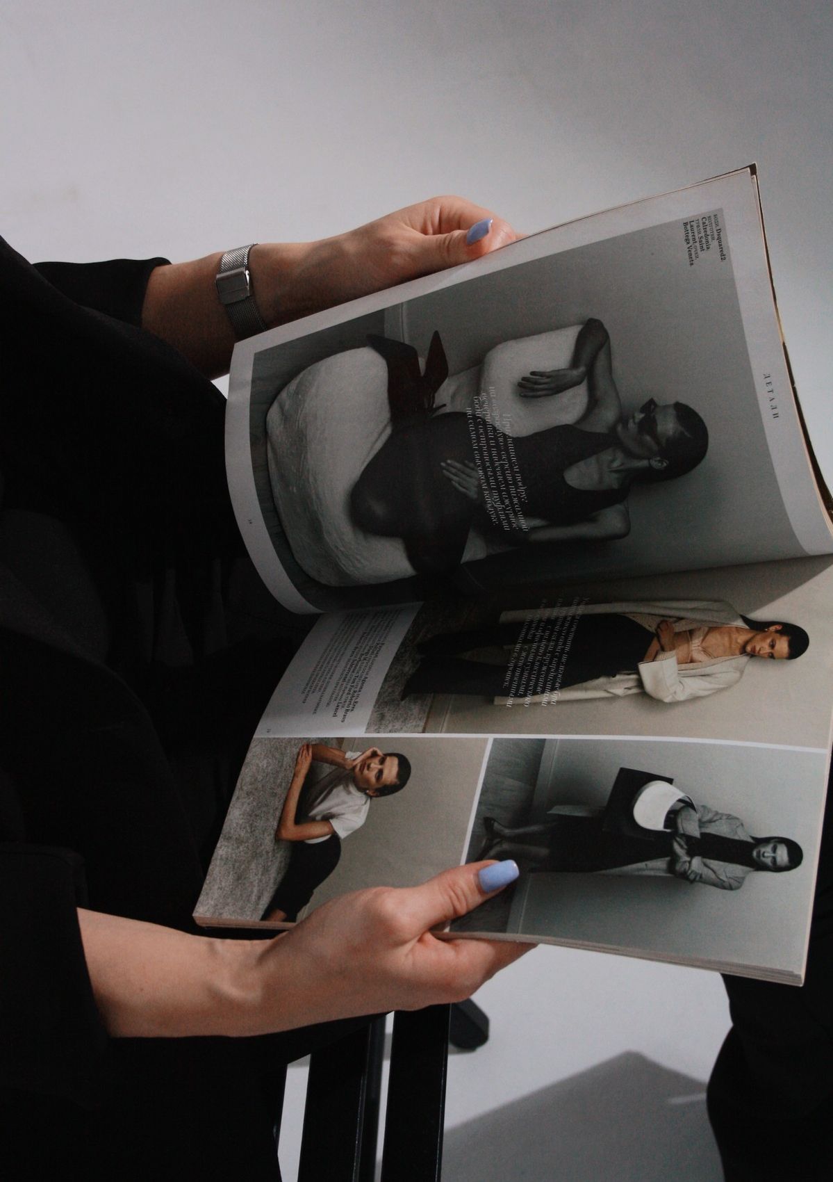 Hands holding open a photography magazine showing black and white portrait spreads.