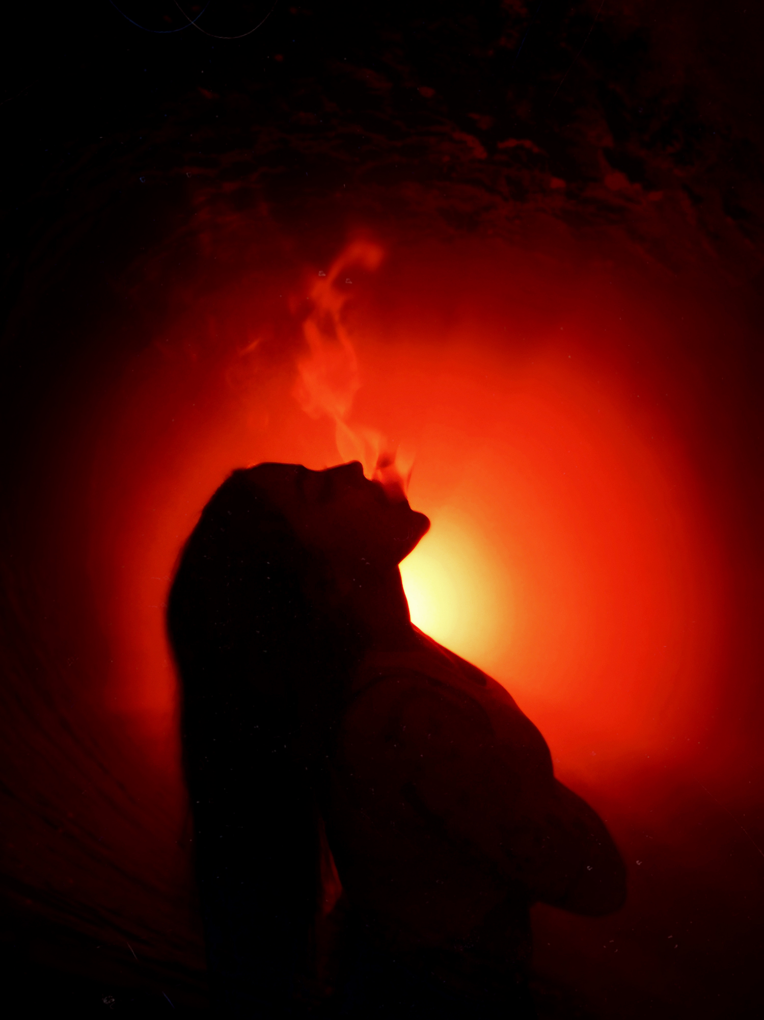 Dramatic silhouette of a figure against a fiery red sunset background creating an ethereal glow.