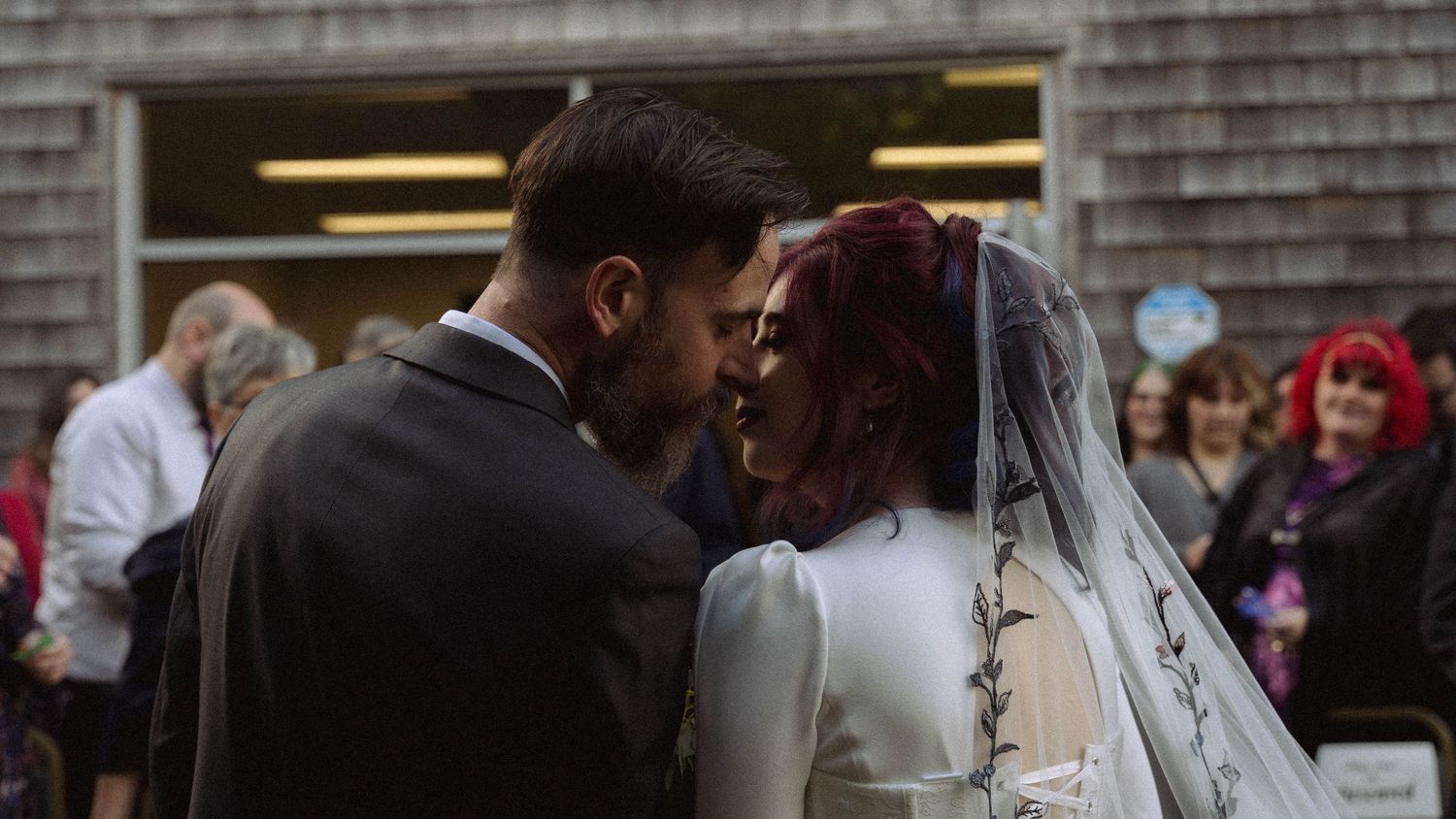 A couple shares an intimate moment during their autumn wedding ceremony.