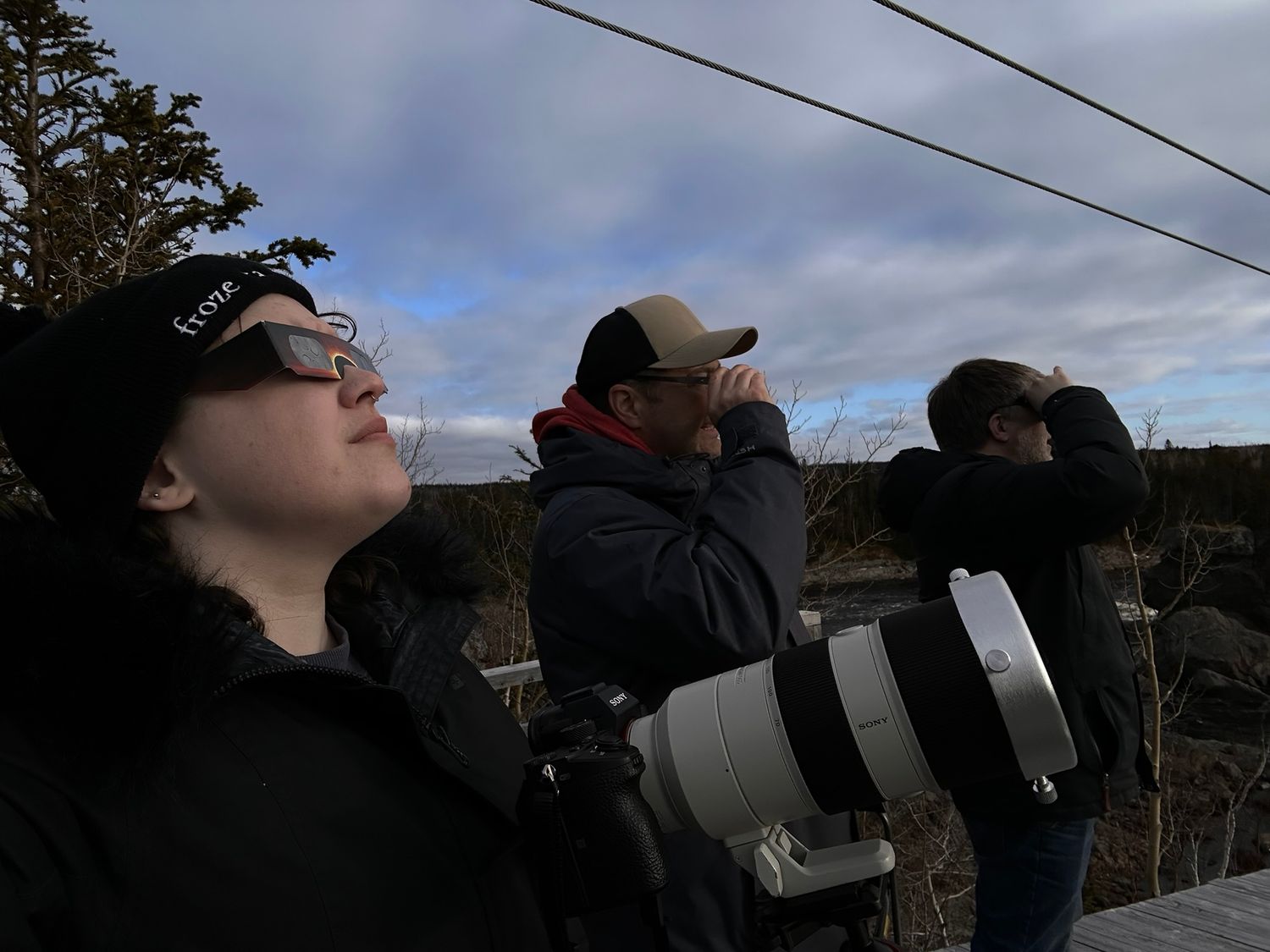 Multiple photographers lined up with cameras and telescopes to photograph the eclipse.