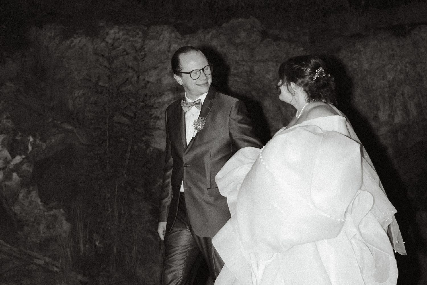 Black and white wedding photos showing romantic moments between newlyweds in formal attire.
