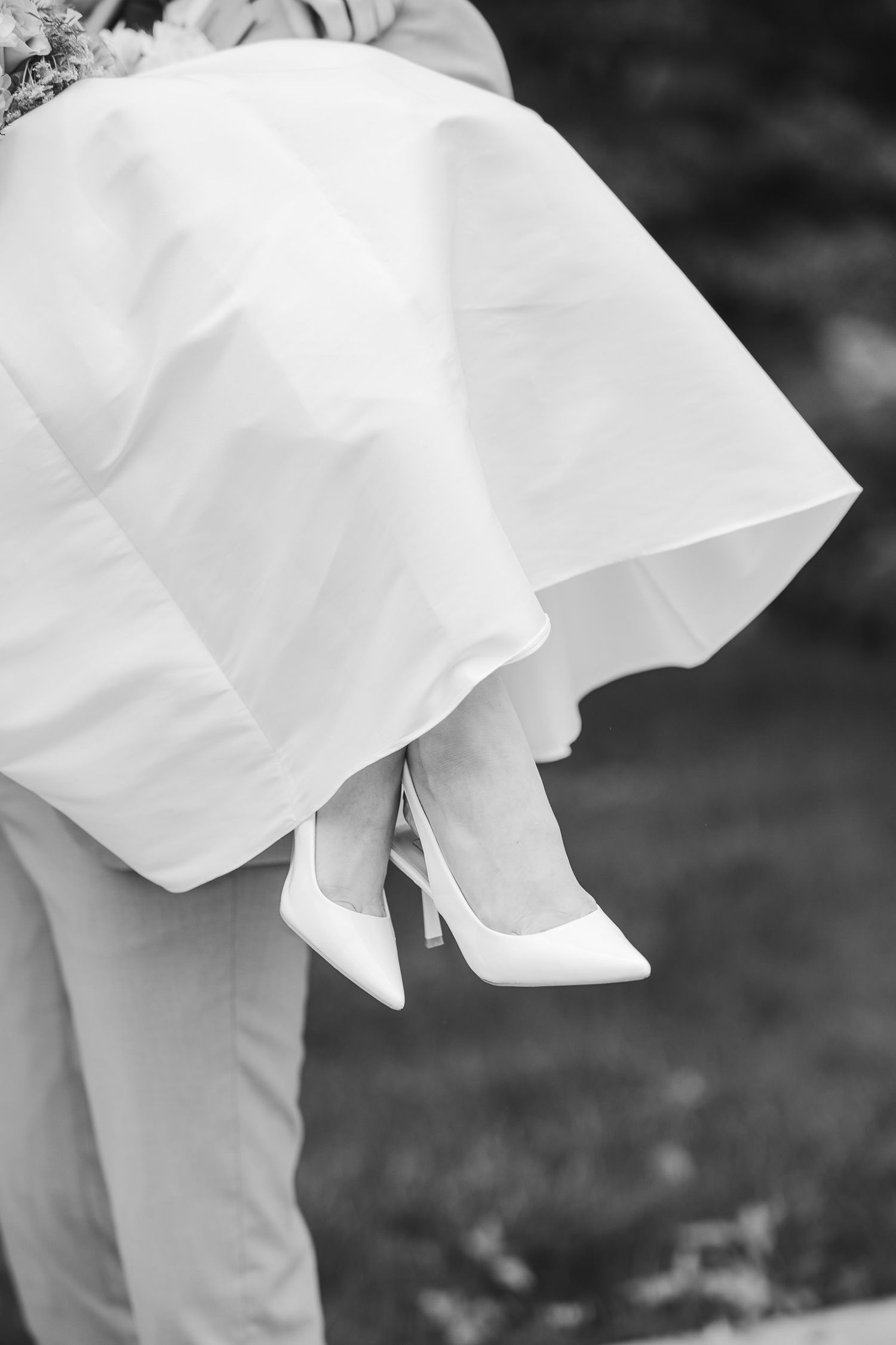 White flowing fabric and shoes create an artistic composition against a dark background.