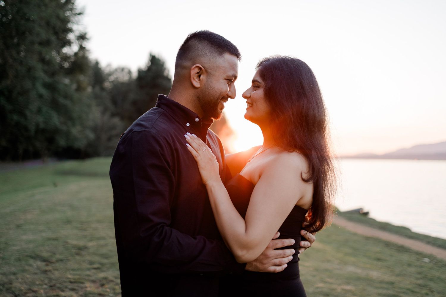 A couple shares tender moments in a series of romantic sunset photos on a grassy hill near water.