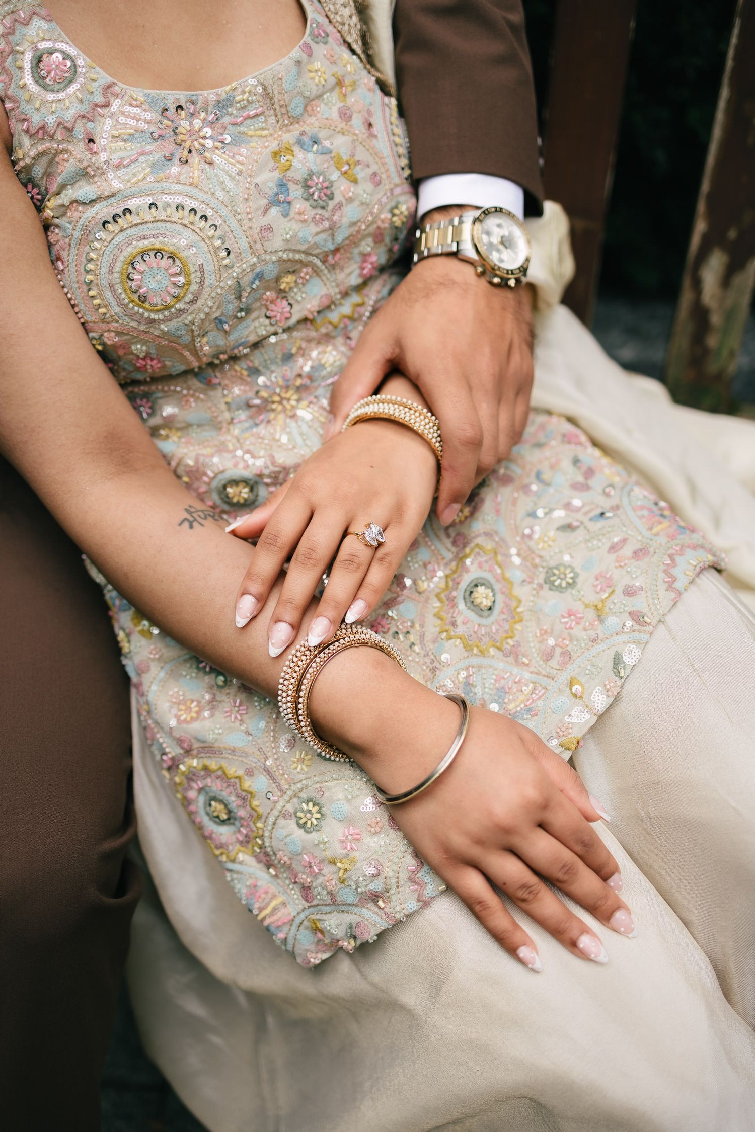 A collection of color photos showing hands adorned with wedding jewelry against an ornate embellished dress.