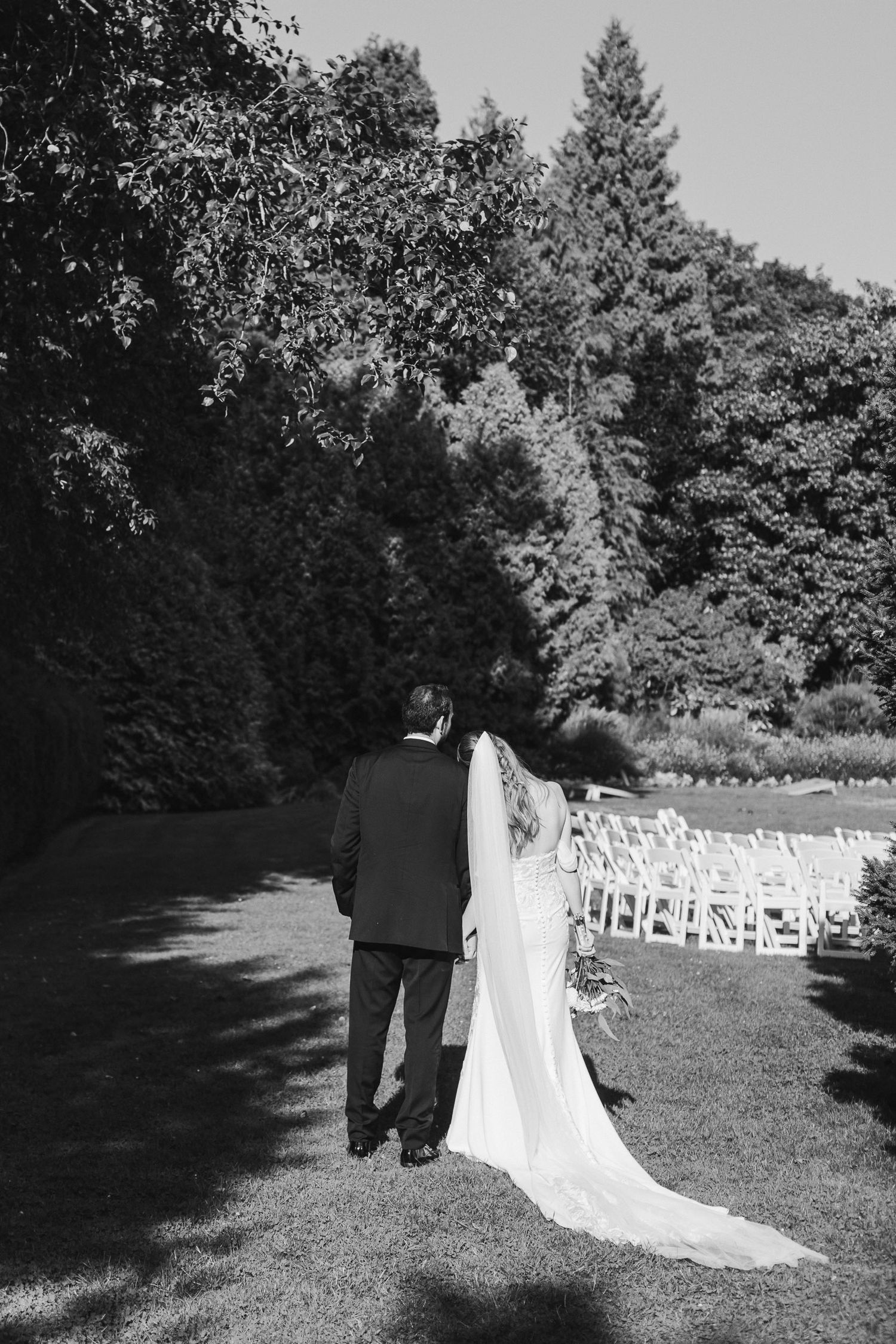 Black and white photo series showing a couple walking away from a garden wedding ceremony setup with white chairs.