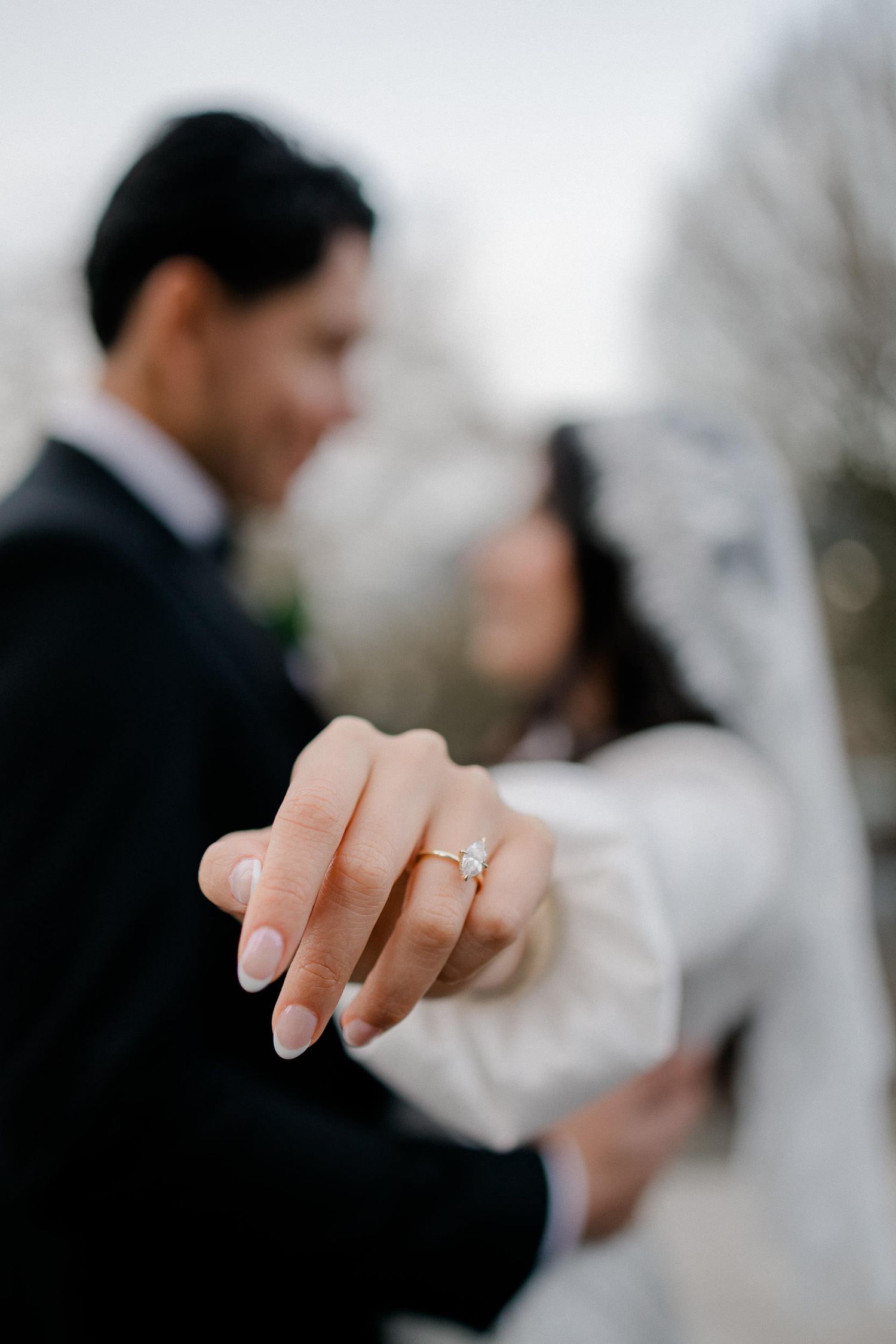 A series of wedding photos showing close-up details of engagement rings and romantic couple moments in soft focus.