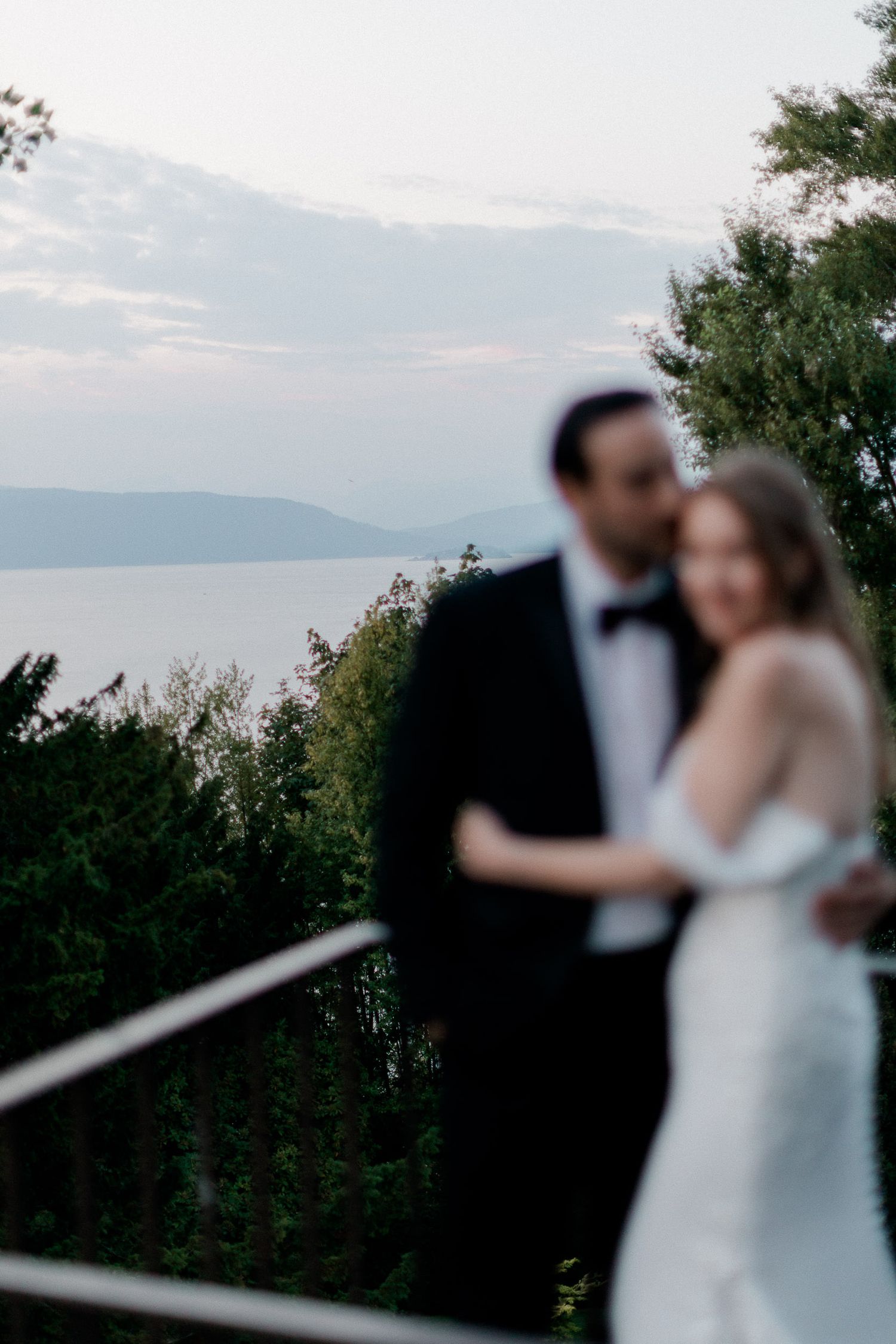 A series of progressively blurred wedding photos showing a couple against a scenic mountain and water backdrop.