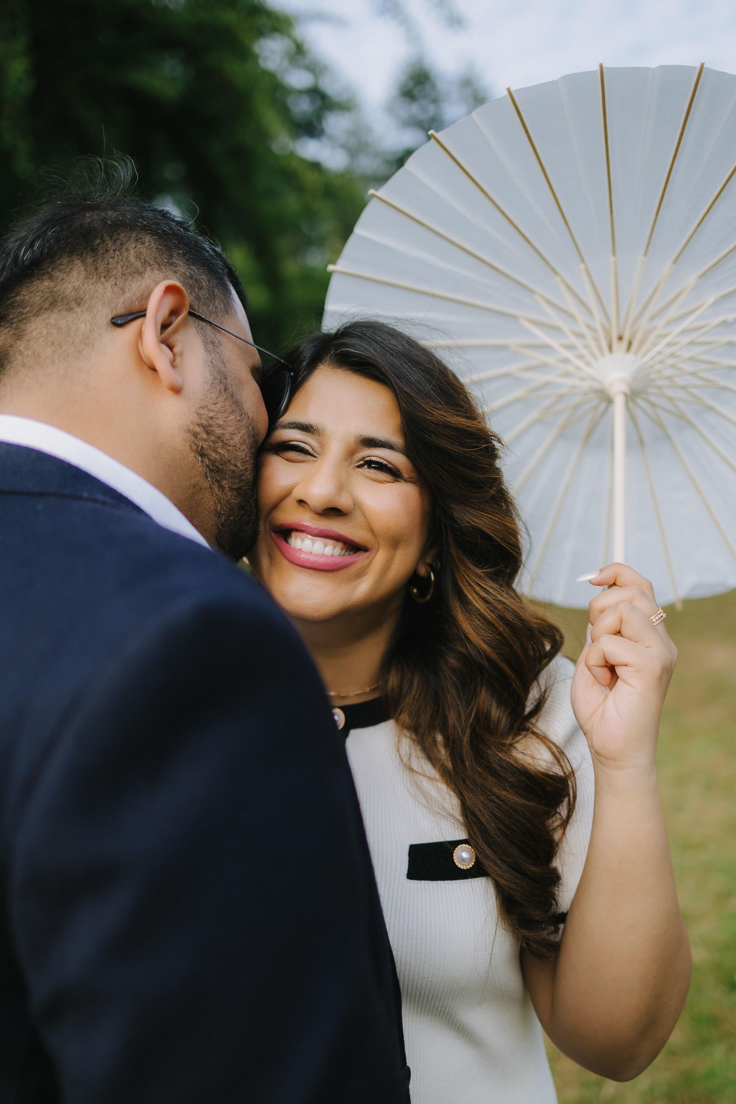 A romantic wedding photo sequence shows a couple sharing tender moments under a white parasol in an outdoor setting.
