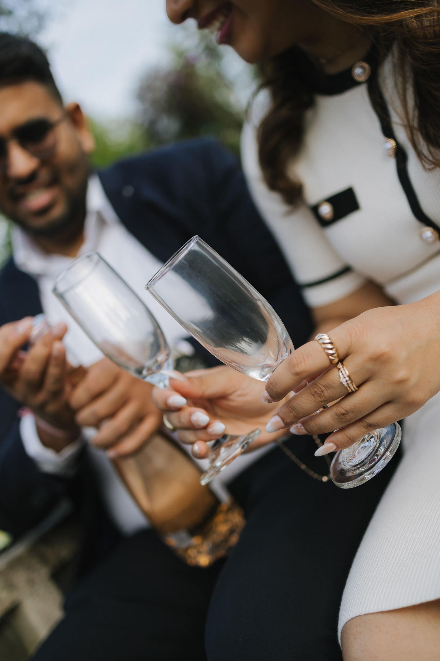 Close-up view of champagne glasses clinking together in a wedding toast celebration.