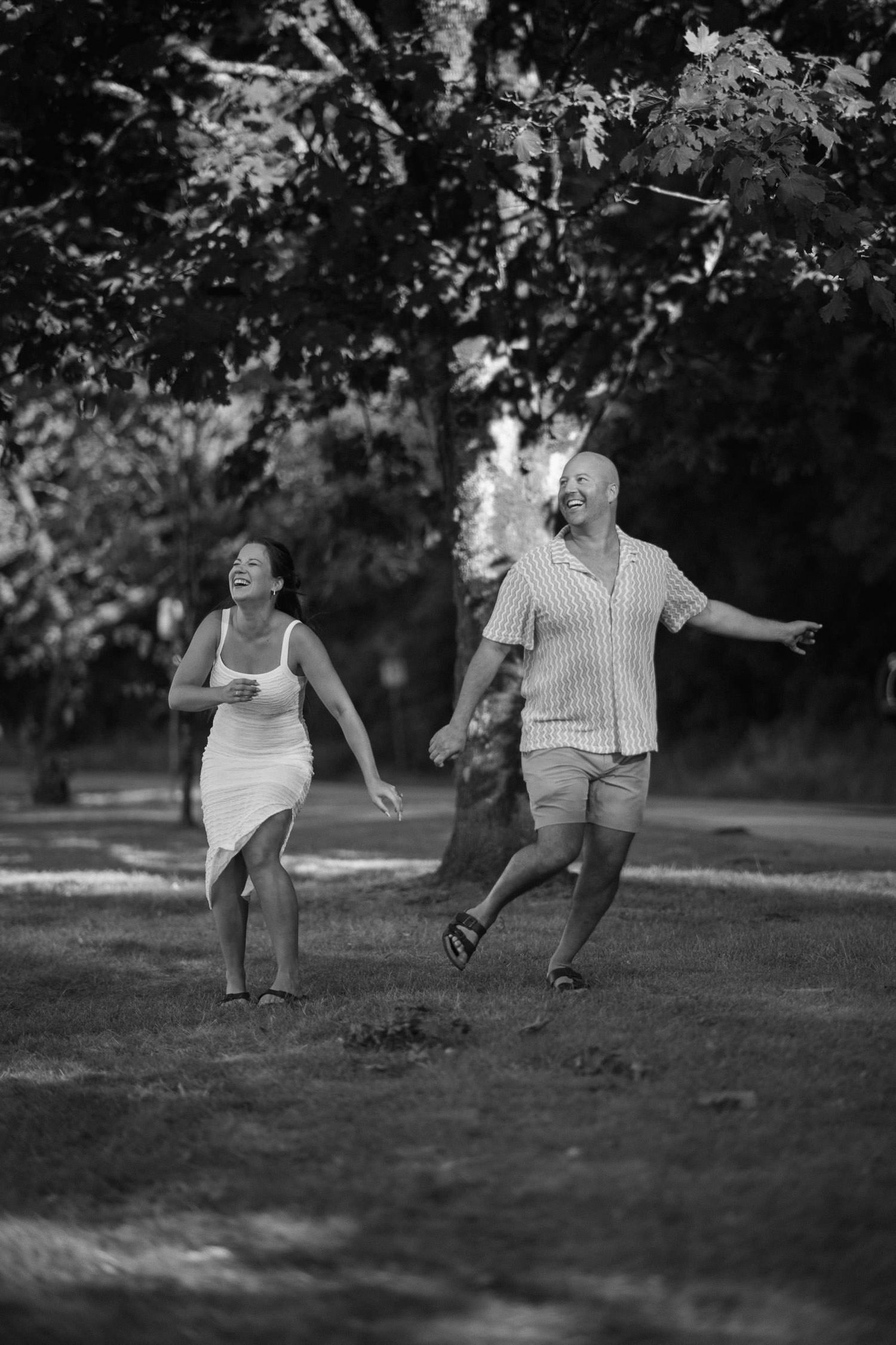 A sequence of black and white photos showing a parent and child playing together outdoors in a park setting.