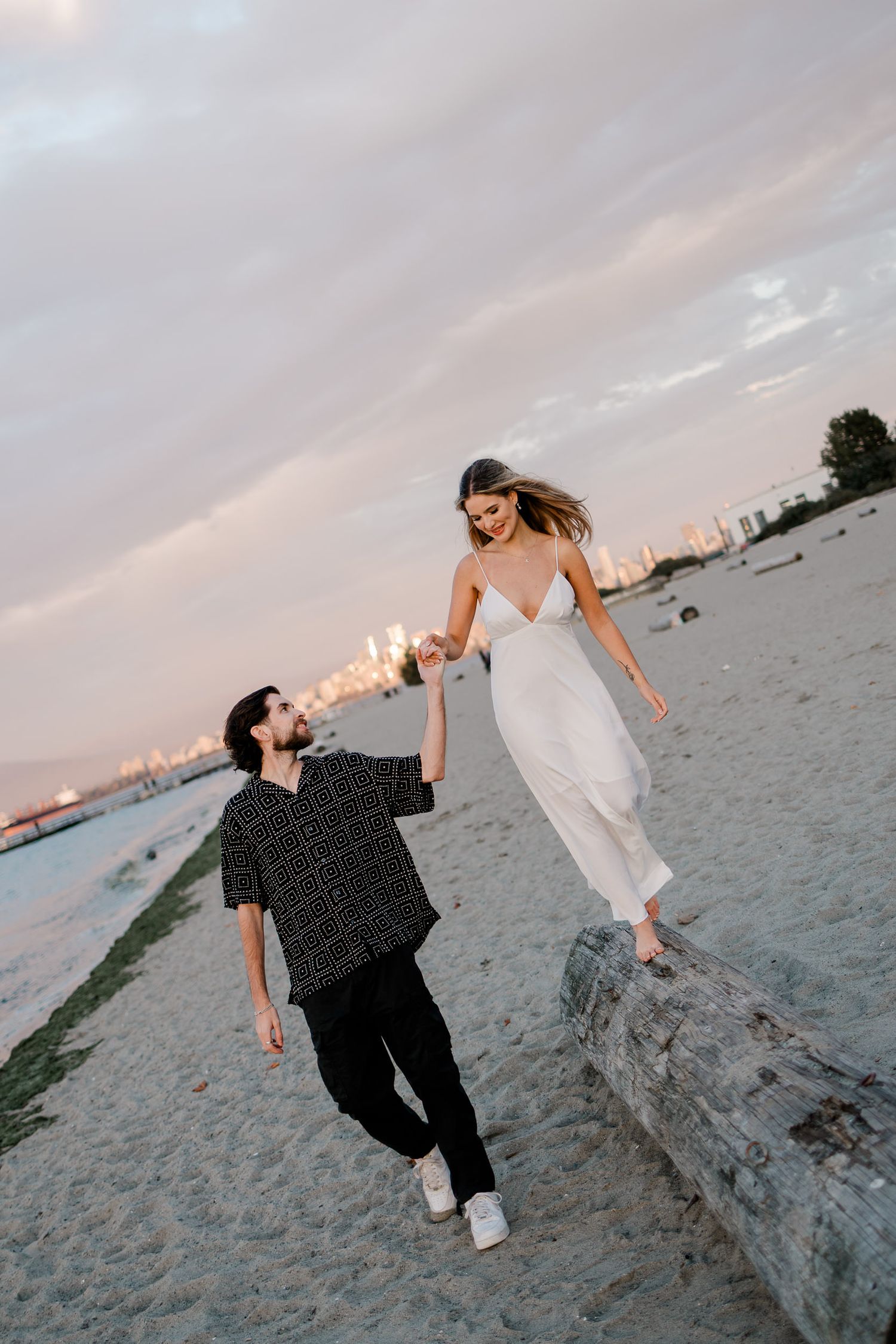 Two people in casual attire playfully posing on a beach at sunset in a sequence of connected photos.