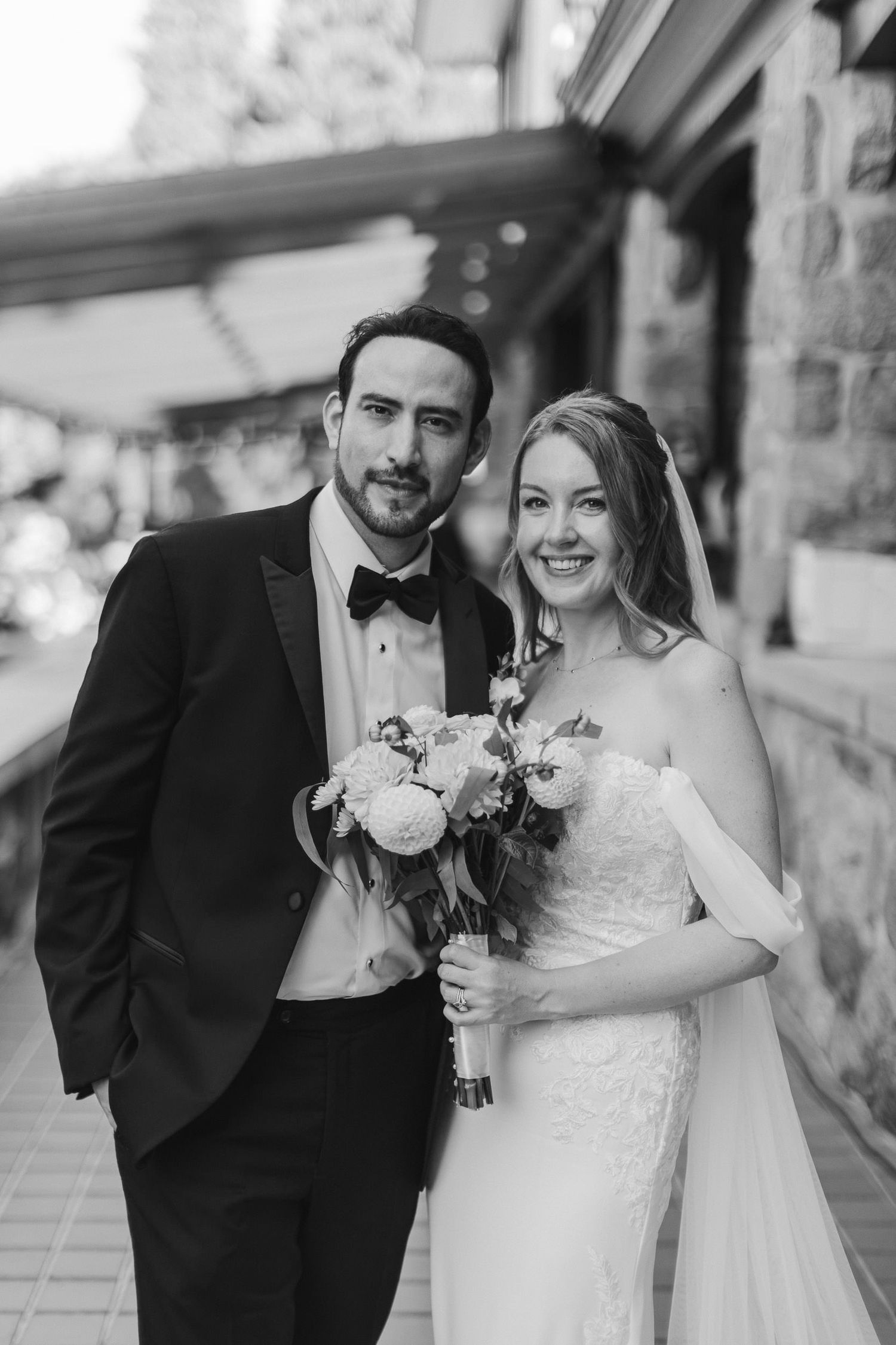 A romantic black and white wedding photo series showing a happy couple embracing and smiling together outdoors.