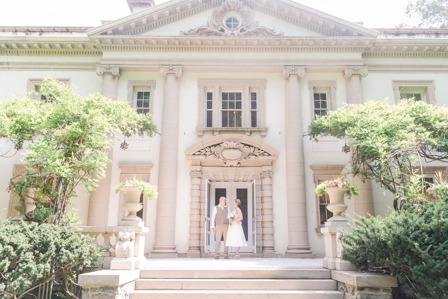 A classic mansion wedding venue with white columns and elegant architectural details.
