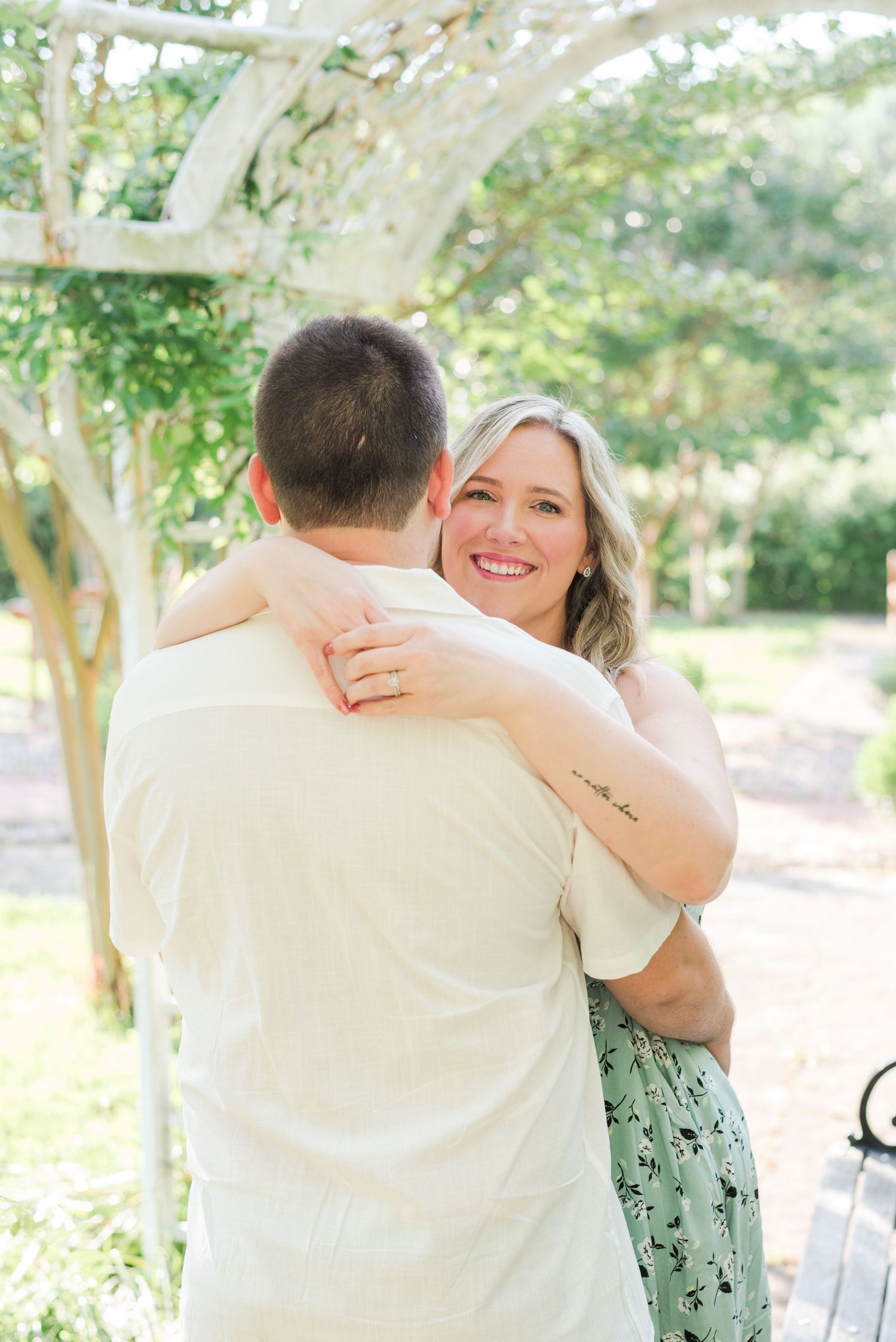 A romantic outdoor photoshoot showing tender embraces and joyful moments in a sunlit garden setting.