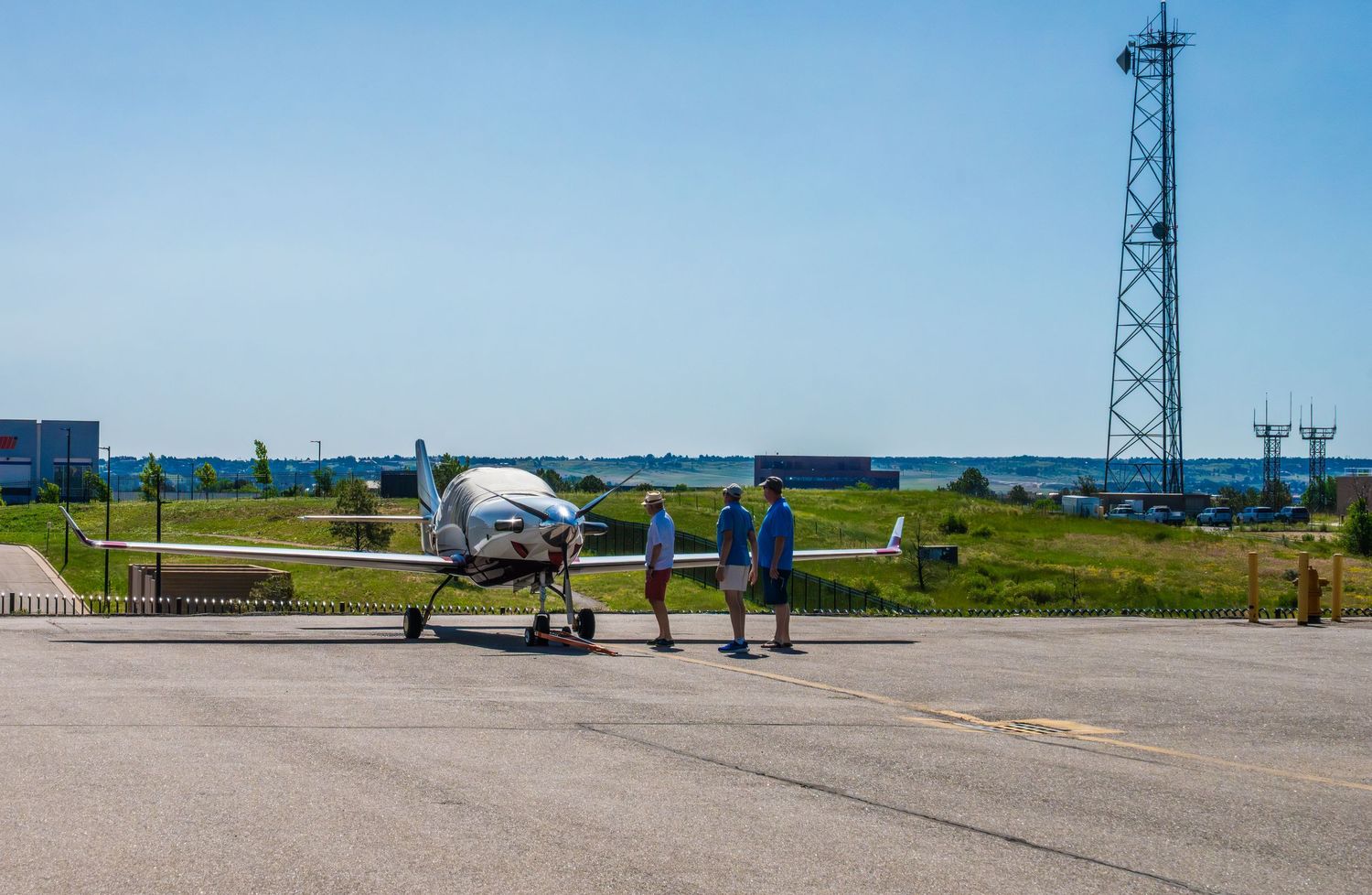 Airport runway and control tower visible across flat terrain on sunny day.
