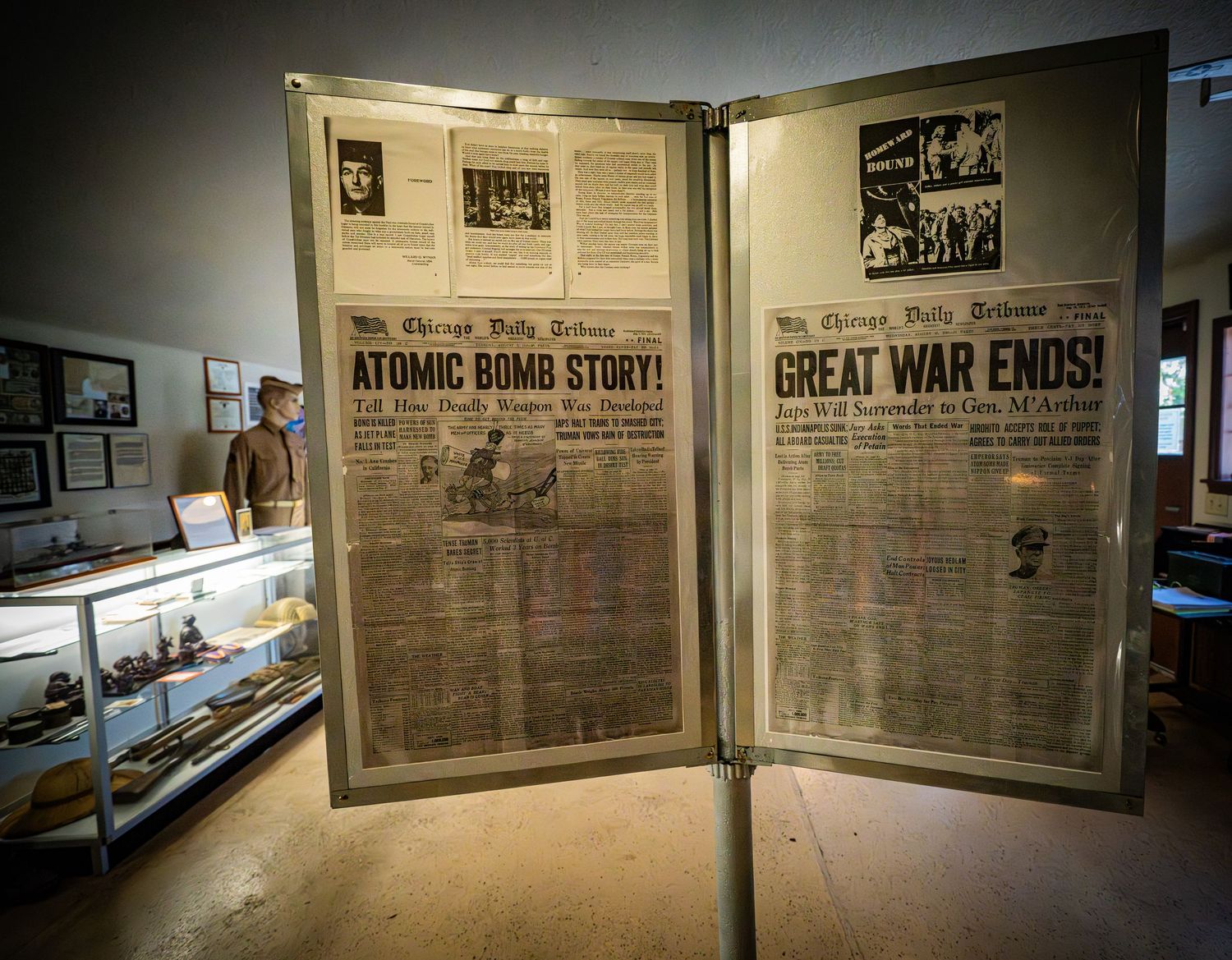 Museum gallery showing vintage newspaper headlines and wartime displays.