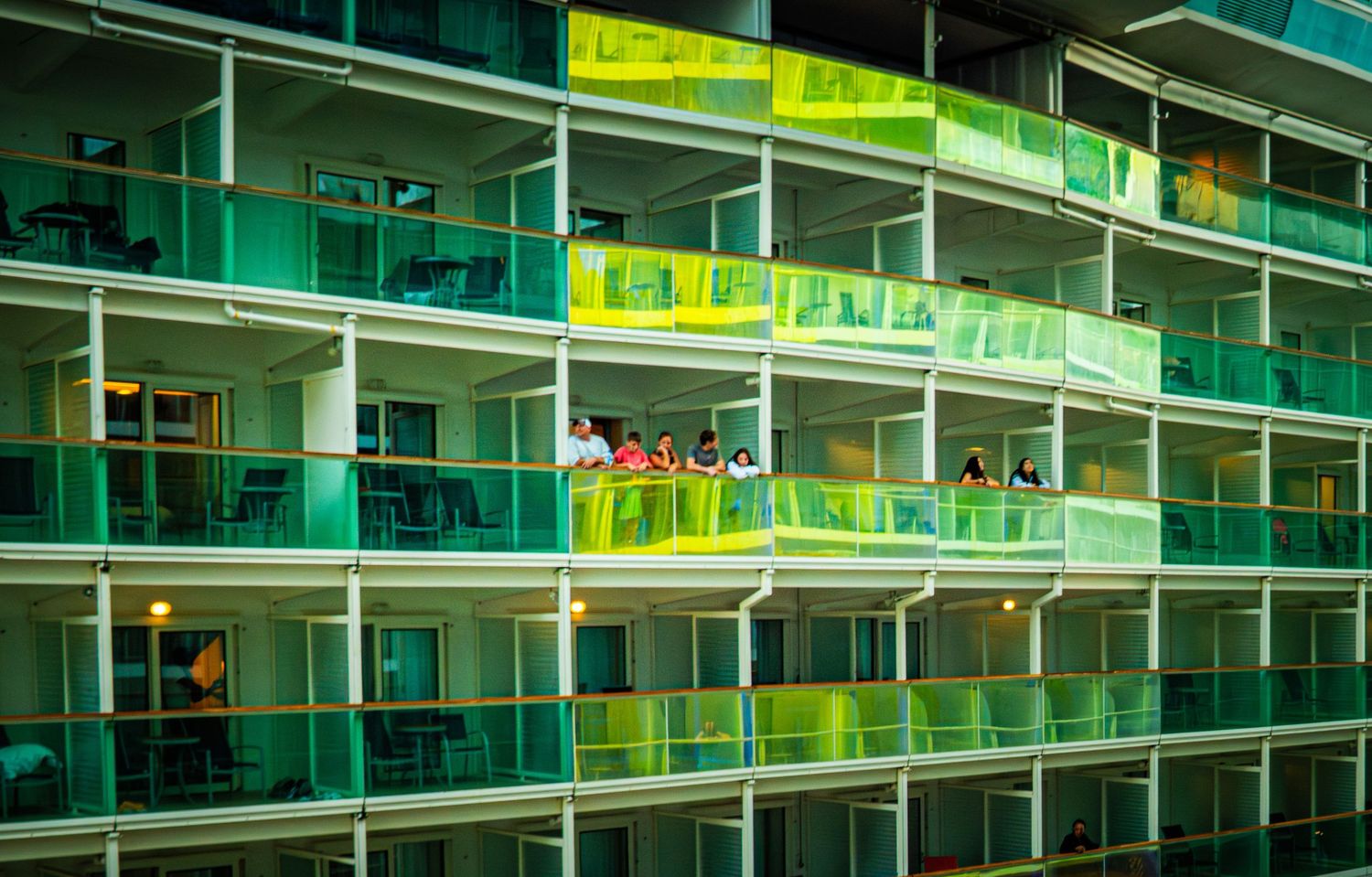 Illuminated green and yellow neon signs glow along multiple levels of shelving in a dimly lit retail environment.