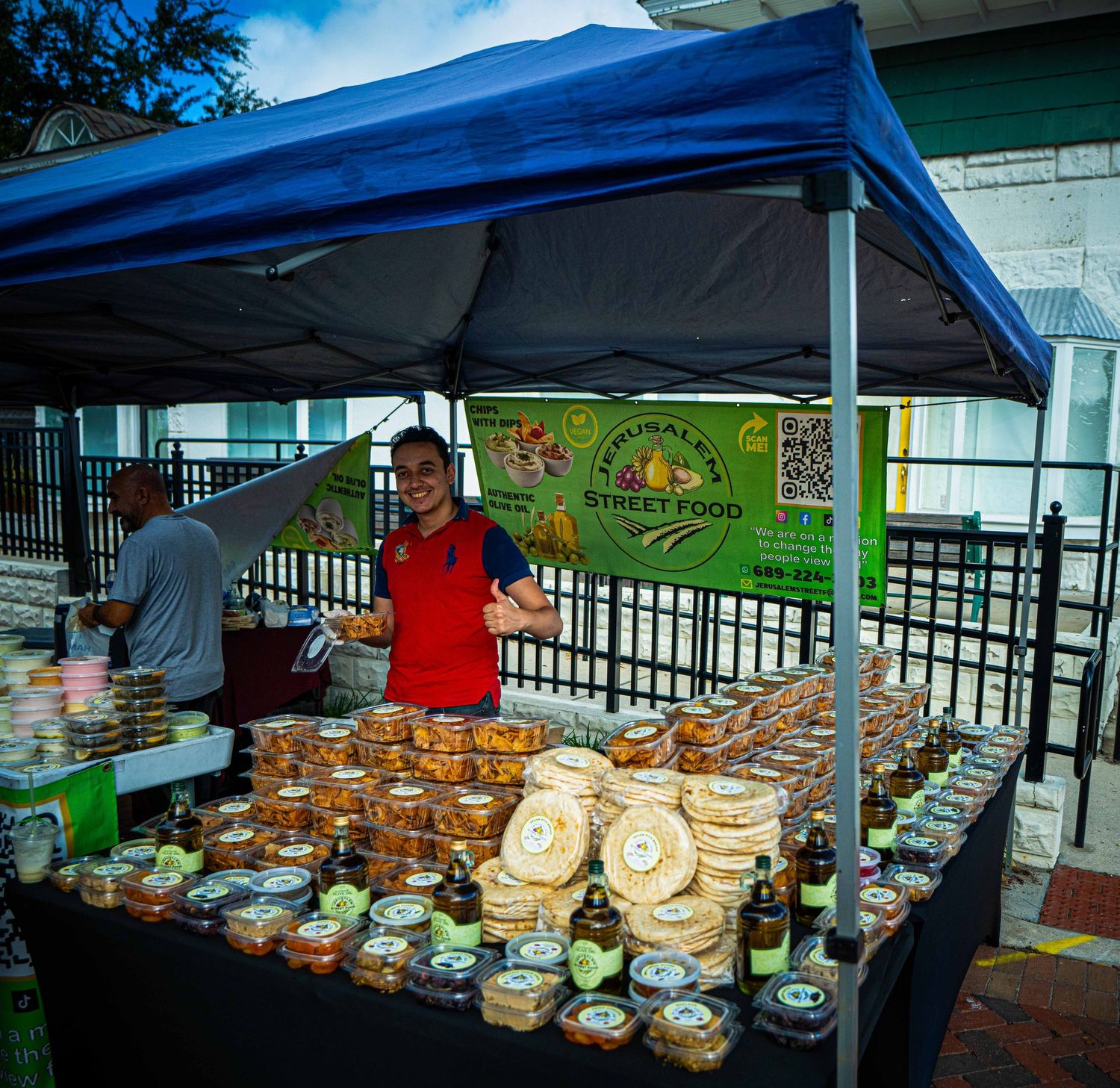 Outdoor market vendor displays rows of fresh coconut bowls and products under blue canopy tents at local bazaar.