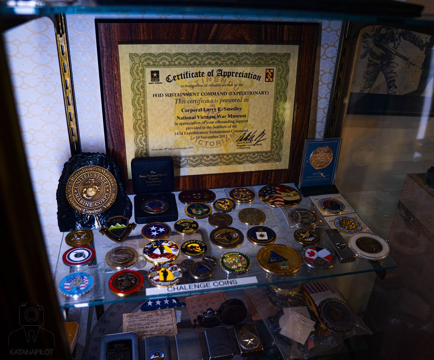 Collection of military awards and certificates arranged in a display case.