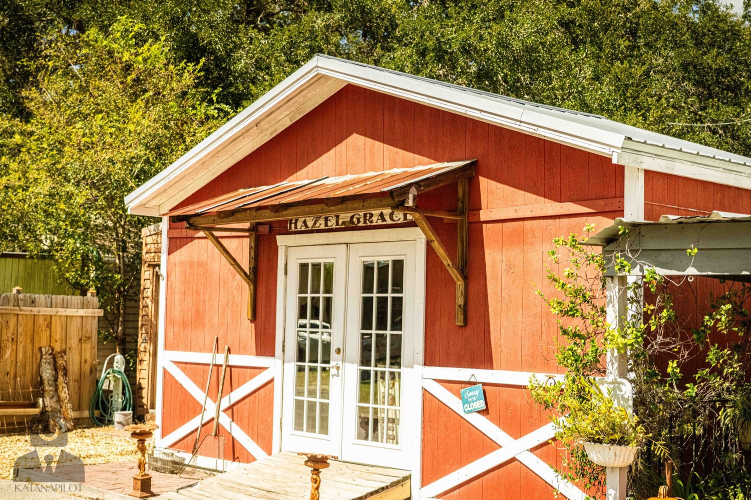 Charming red barn-style building with white trim and French doors.