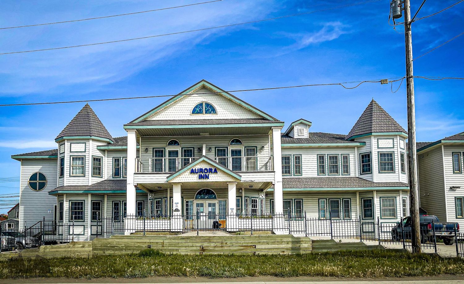 Panoramic view of white coastal houses with pitched roofs along the shoreline.
