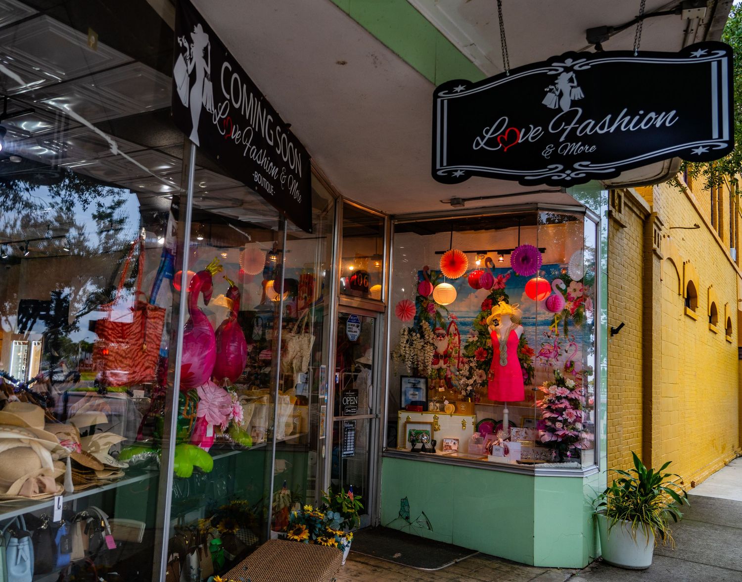 Colorful boutique storefront with mannequins and festive decorations in the display window.