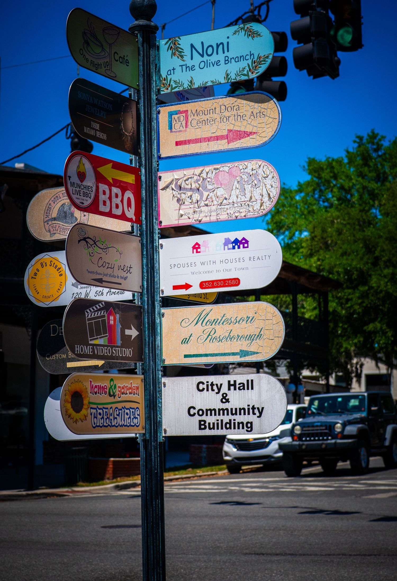 Decorative pole with multiple business directory signs pointing to local attractions and restaurants.