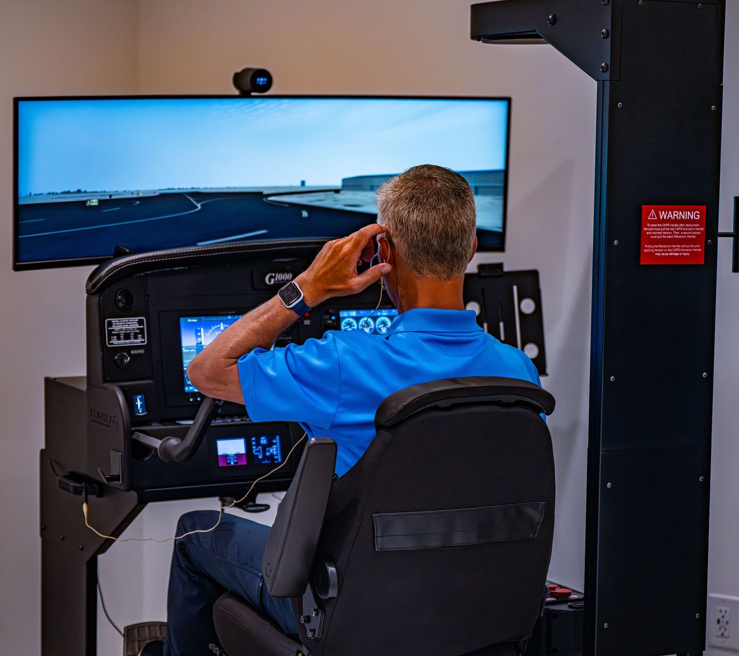 Flight training facility with multiple simulator stations and large display screens.