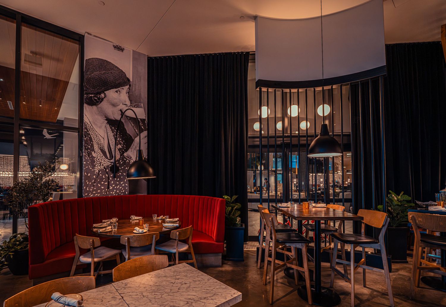 Modern restaurant interior with warm lighting, wooden accents, and comfortable seating arrangements.